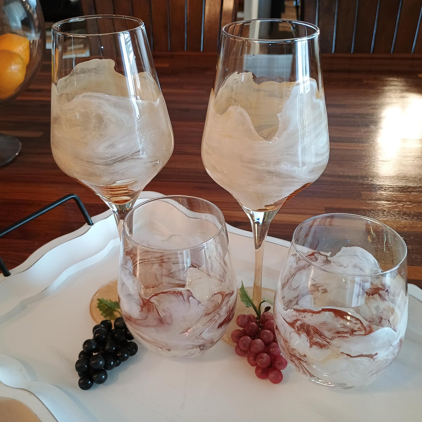 Set of four handmade marbled glassware on a tray with grapes