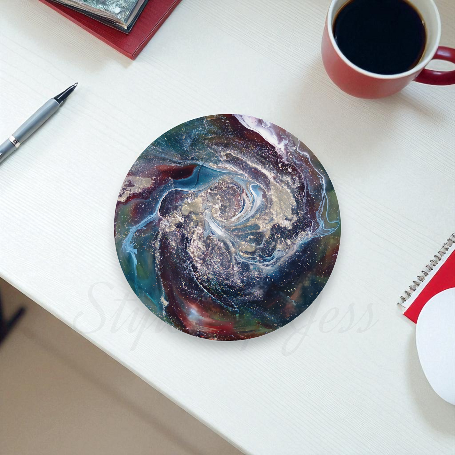 Round marbled mouse pad on a white surface with a cup of coffee and pen.