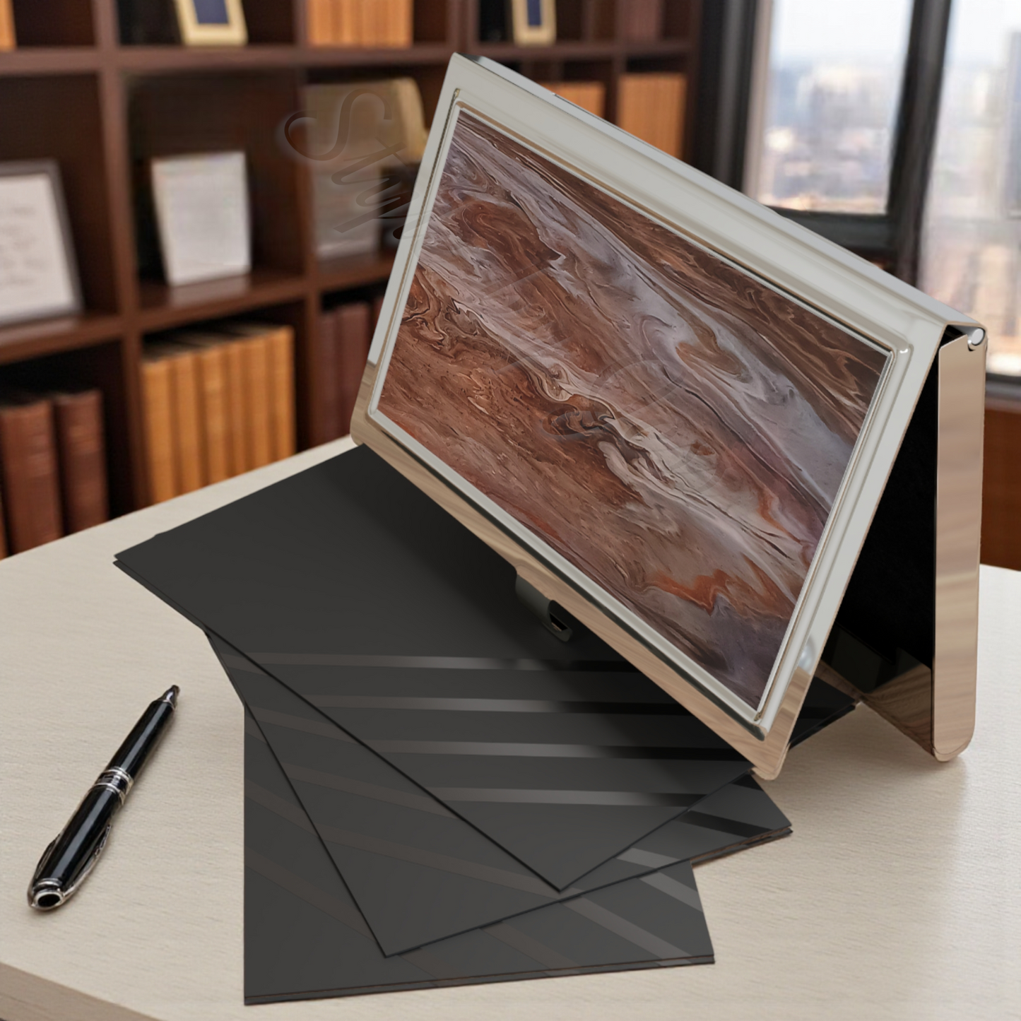 Professional Business Card Holder open with business cards on a table beneath it on a desk next to a pen and black paper, with a bookshelf and window in the background