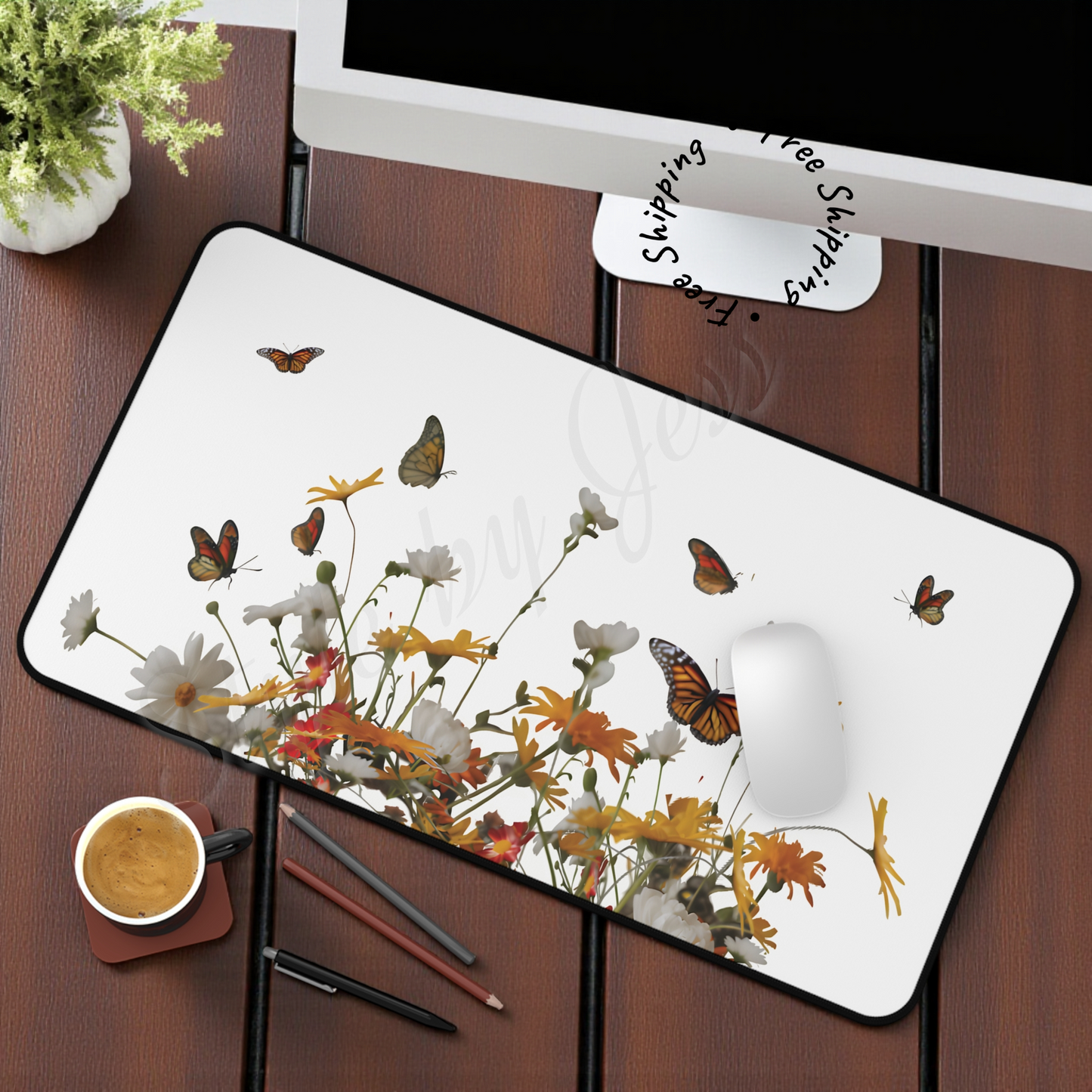Desk setup with a floral and butterfly design mouse pad, computer, and coffee cup.