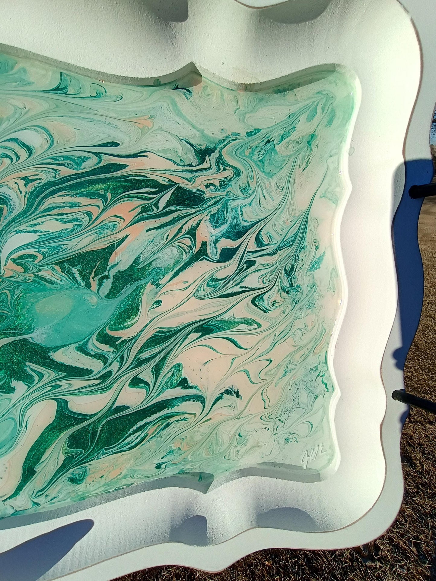 Marbled green and pink design on a white surface with blue accents