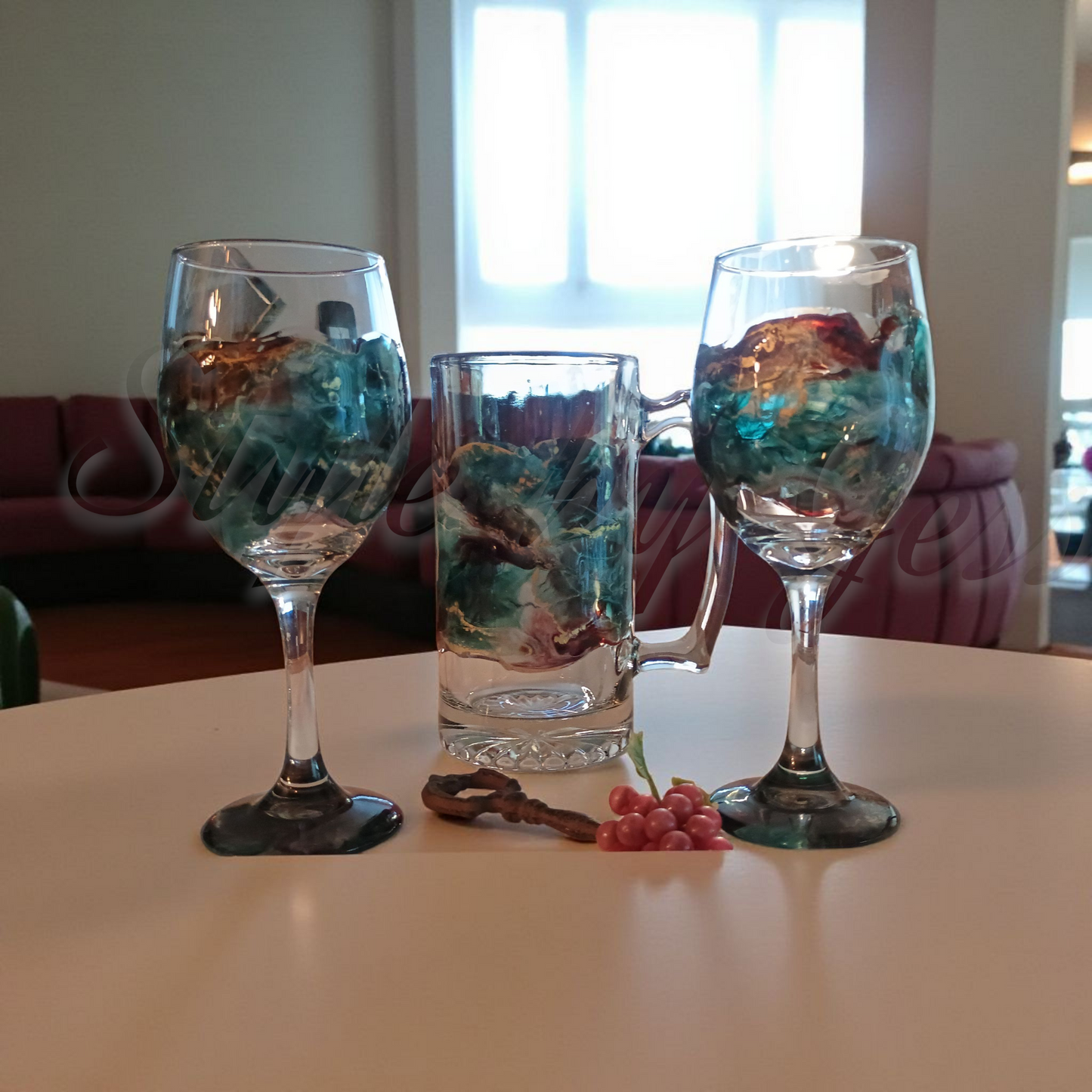 Two wine glasses and a mug with artistic designs on a table. Custom gift for dad and gift for mom a Style By Jess creation.