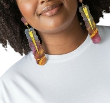 Person wearing colorful earrings with a white background