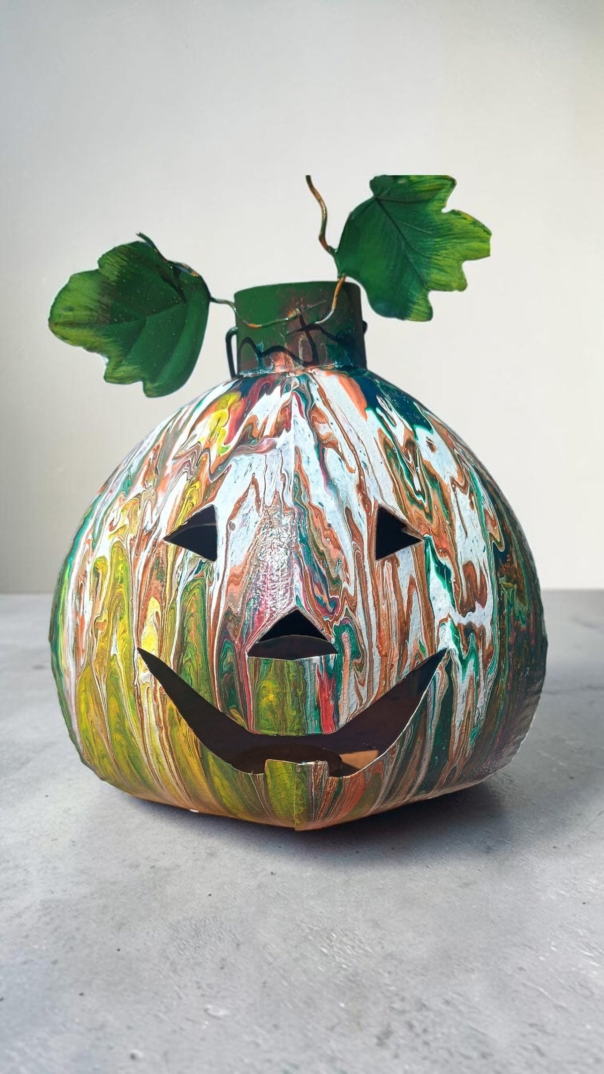 Halloween jack-o'-lantern home decor — hand-poured acrylic fluid art in green, orange, copper, and white on upcycled metal pumpkin with decorative leaves, one of a kind by Style By Jess at Gotta Have It Design