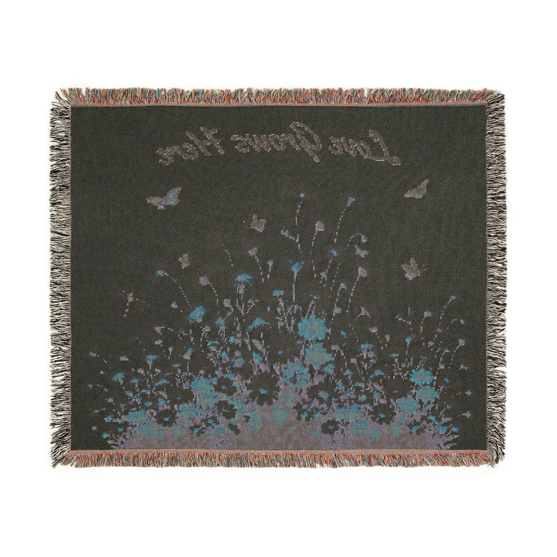 Decorative throw blanket with floral design and text on a plain background