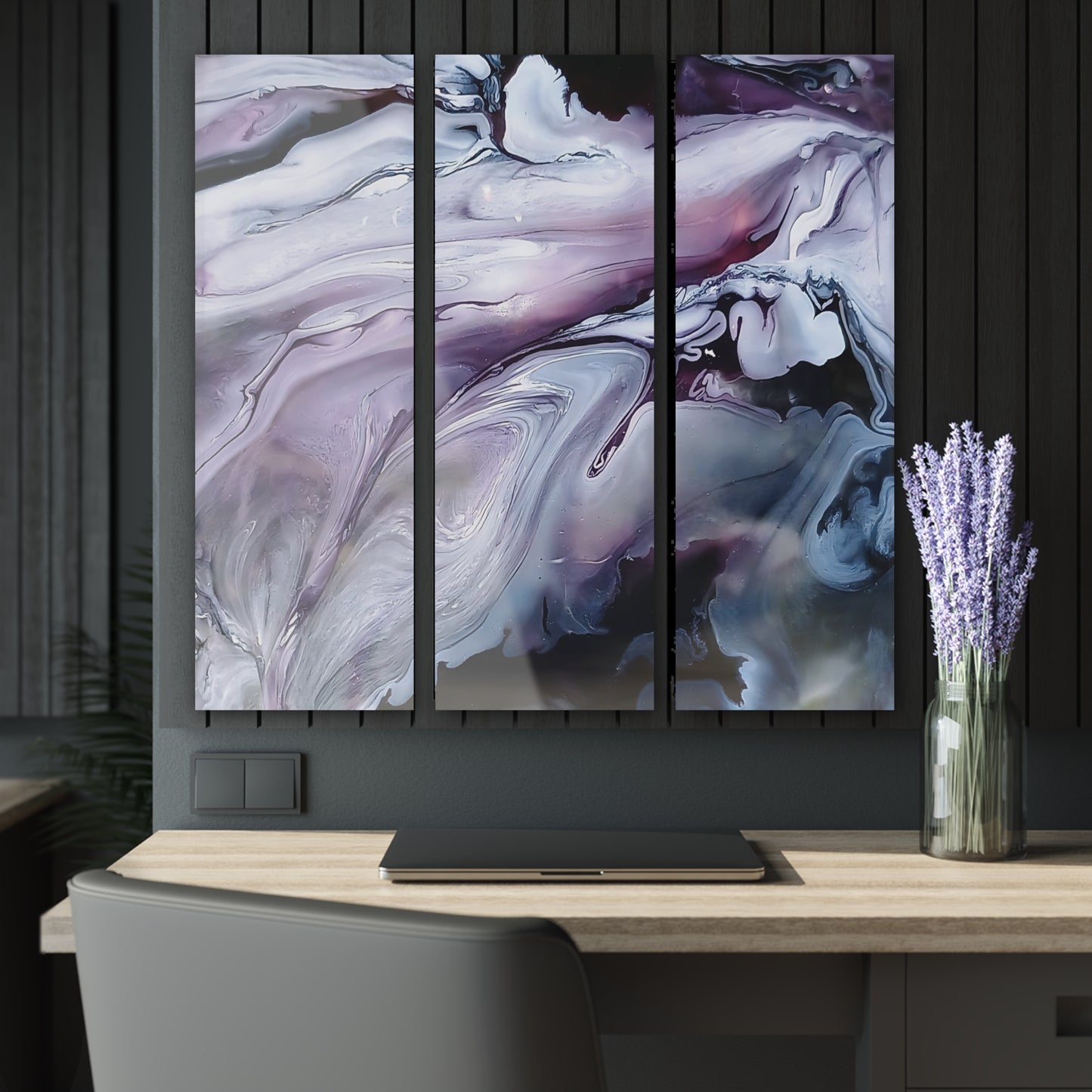 Abstract art triptych on a wall above a desk with a vase of lavender.
