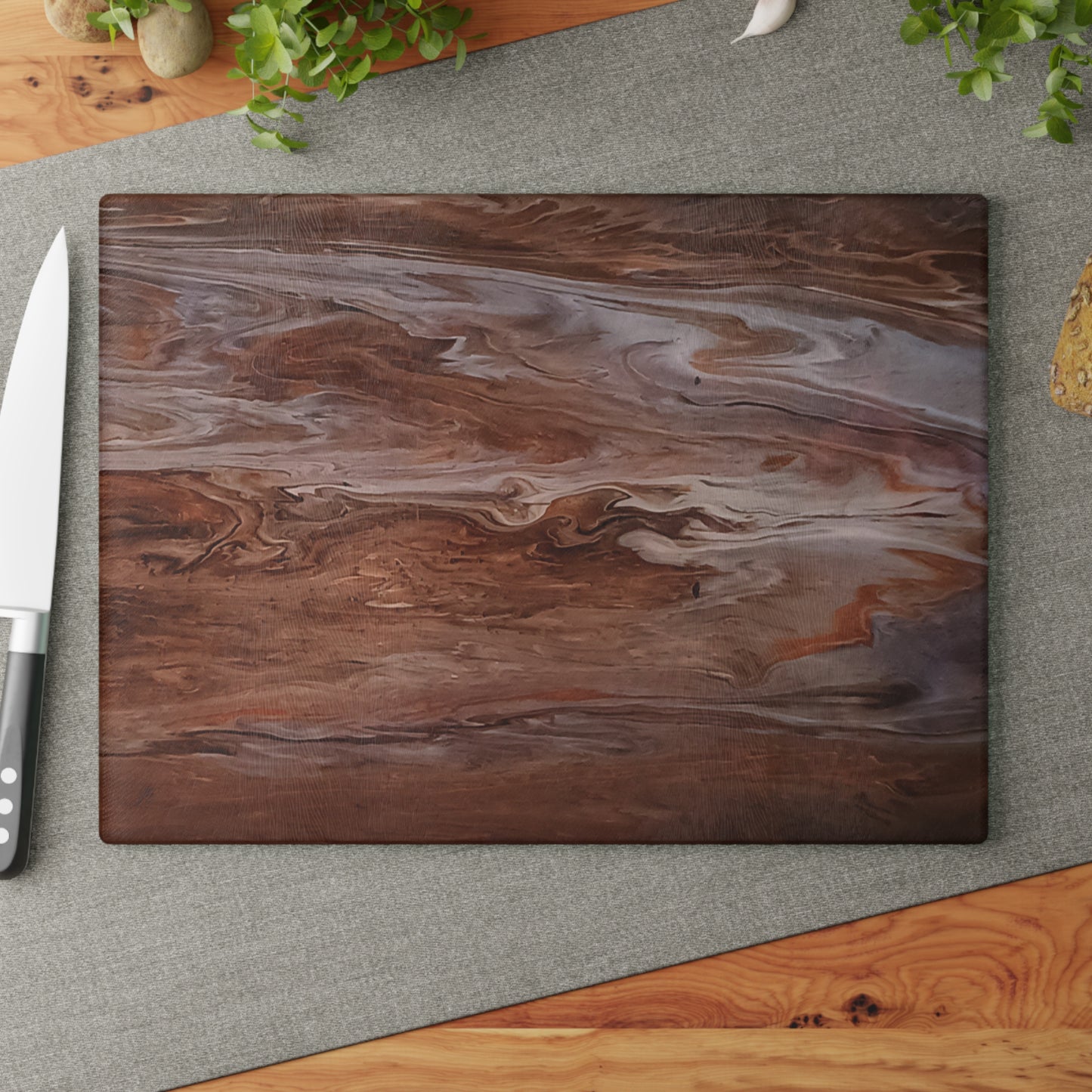 Marble-patterned cutting board with a knife on a gray surface