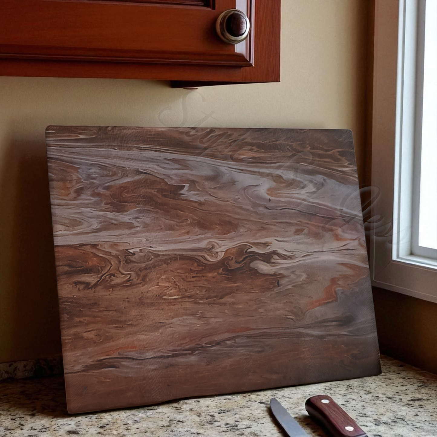 Marble-patterned cutting board on a kitchen counter with a knife and knife block.
