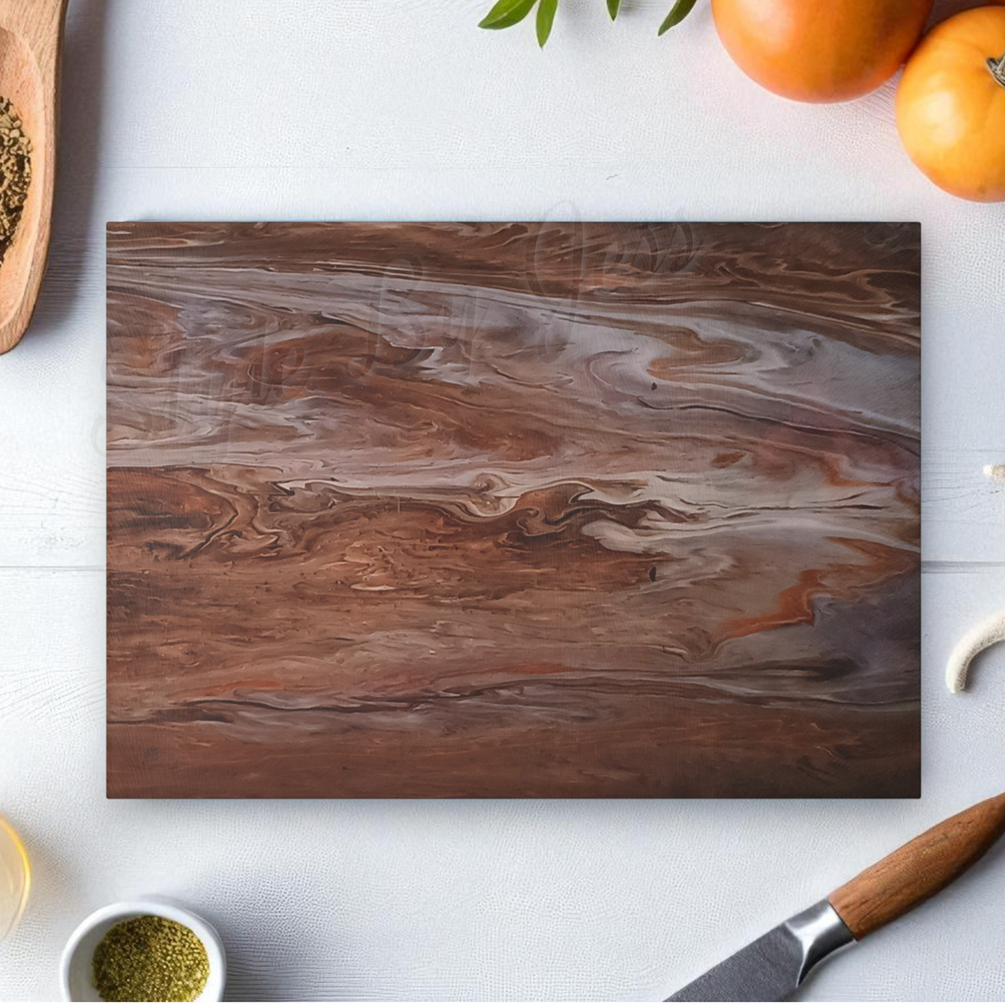 Glass cutting board with a marbled pattern on a white surface with kitchen items.