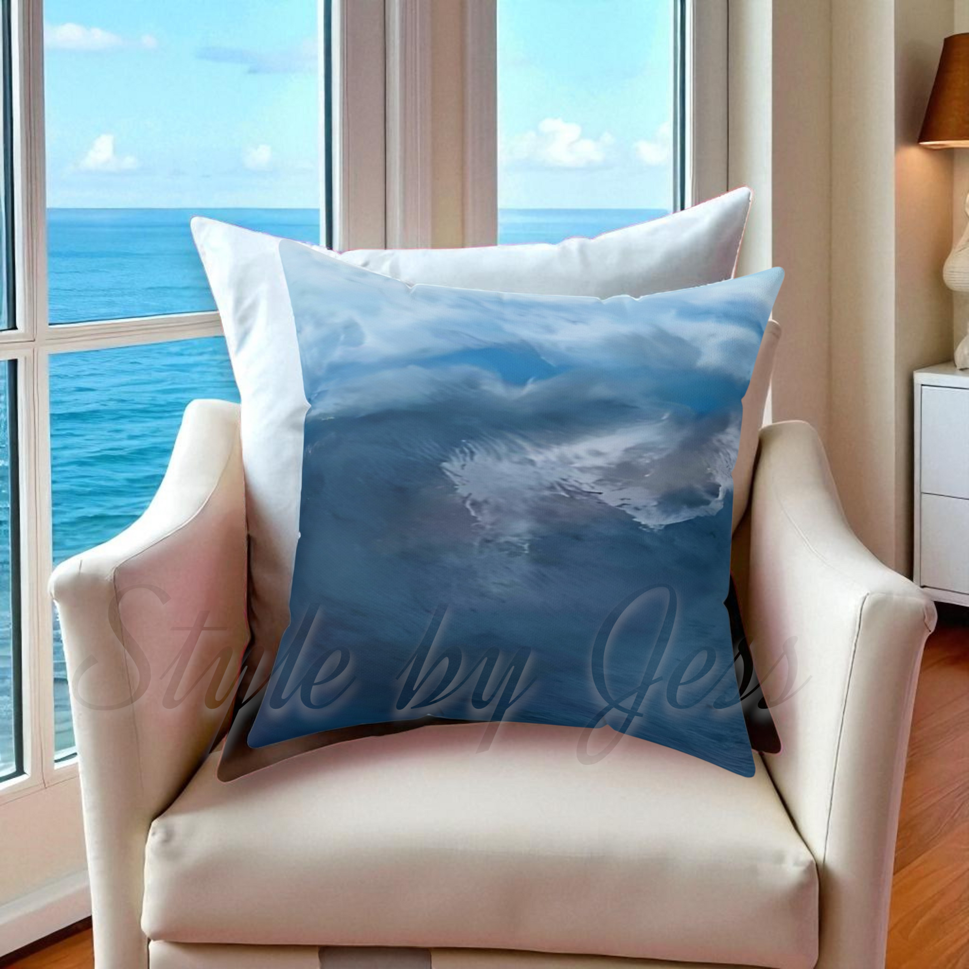 Decorative pillow with ocean design on a chair by a window with a view of the sea.