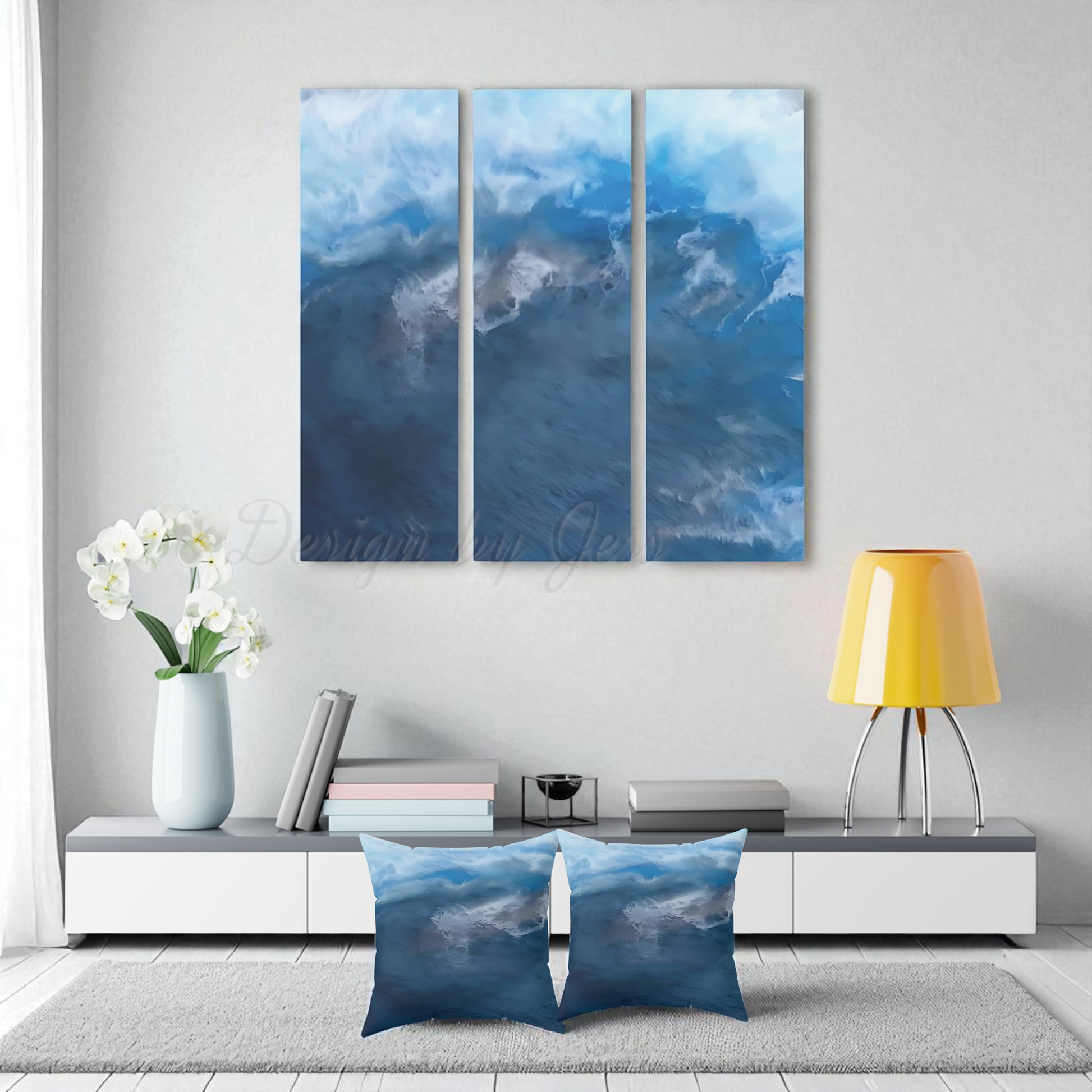 Three-panel wall art of abstract wave or sky image two matching throw pillows on the floor in a modern living room.