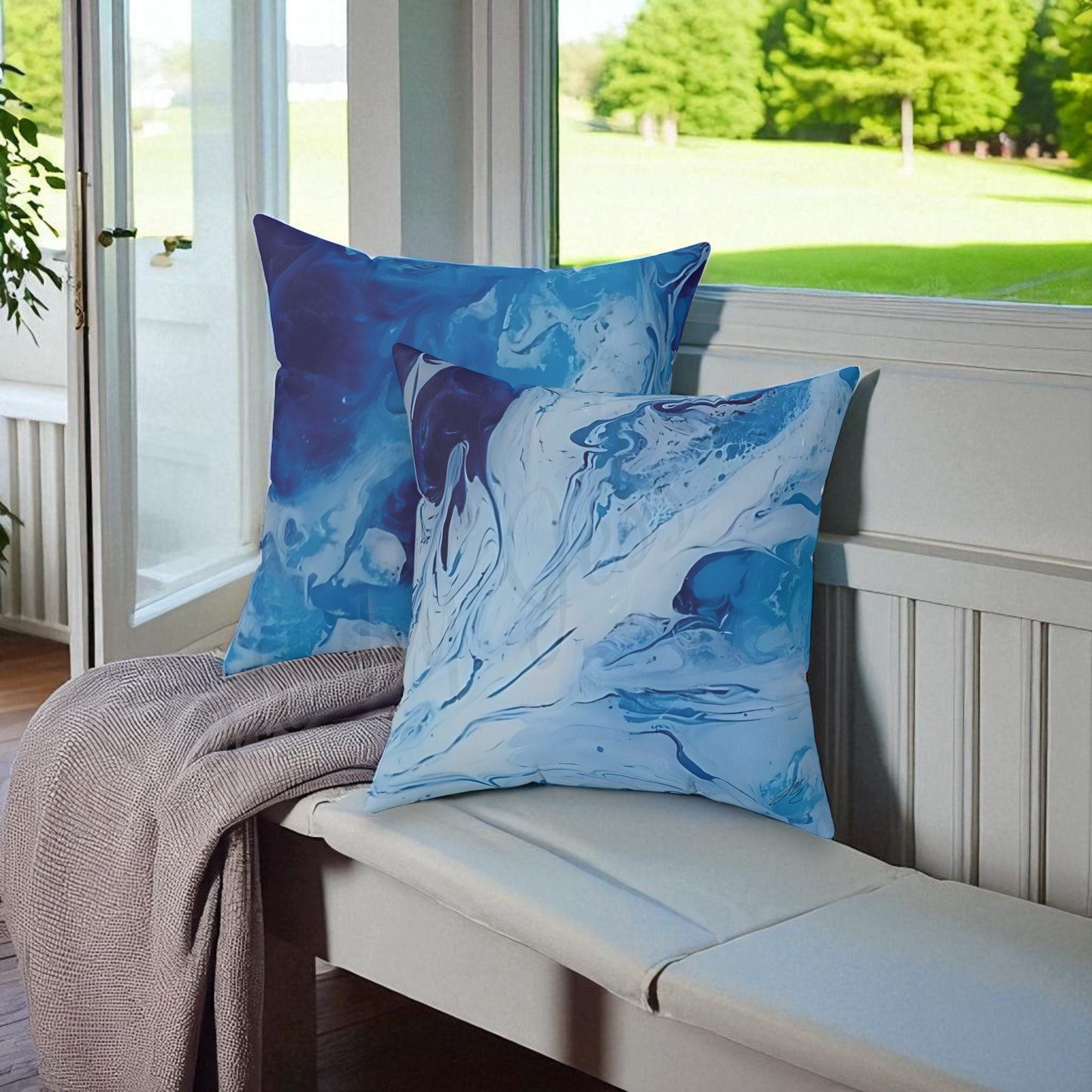 Blue abstract-patterned pillows on a bench with a view of greenery outside.