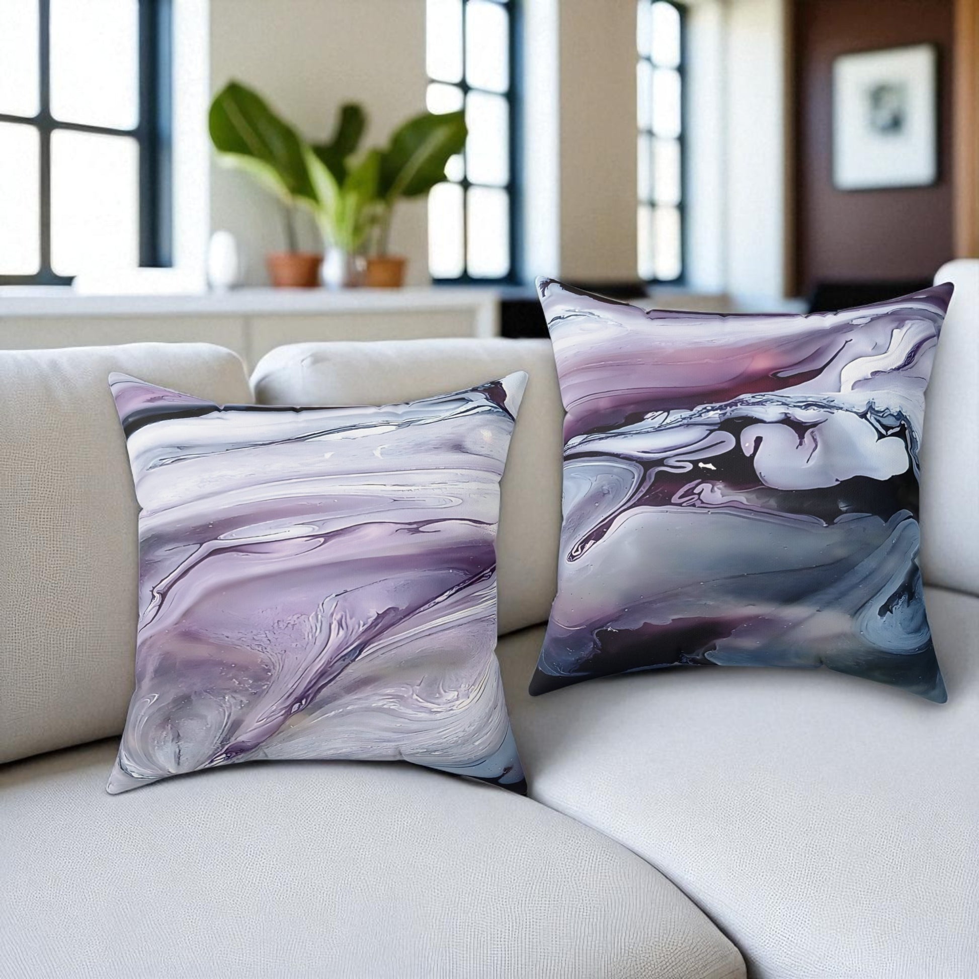 Two marbled patterned pillows on a white sofa with a blurred indoor background.