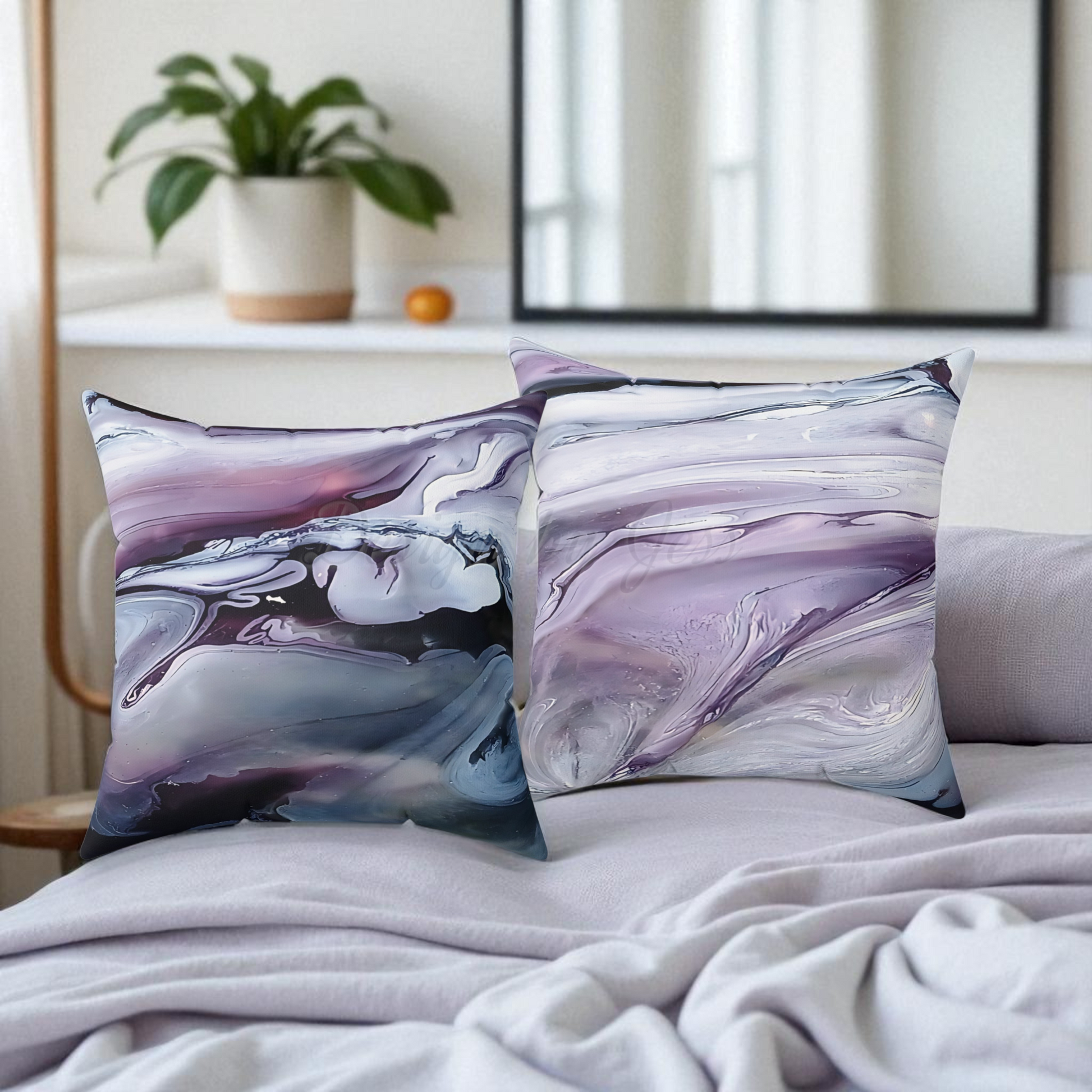 Two abstract-patterned pillows on a bed with a neutral background