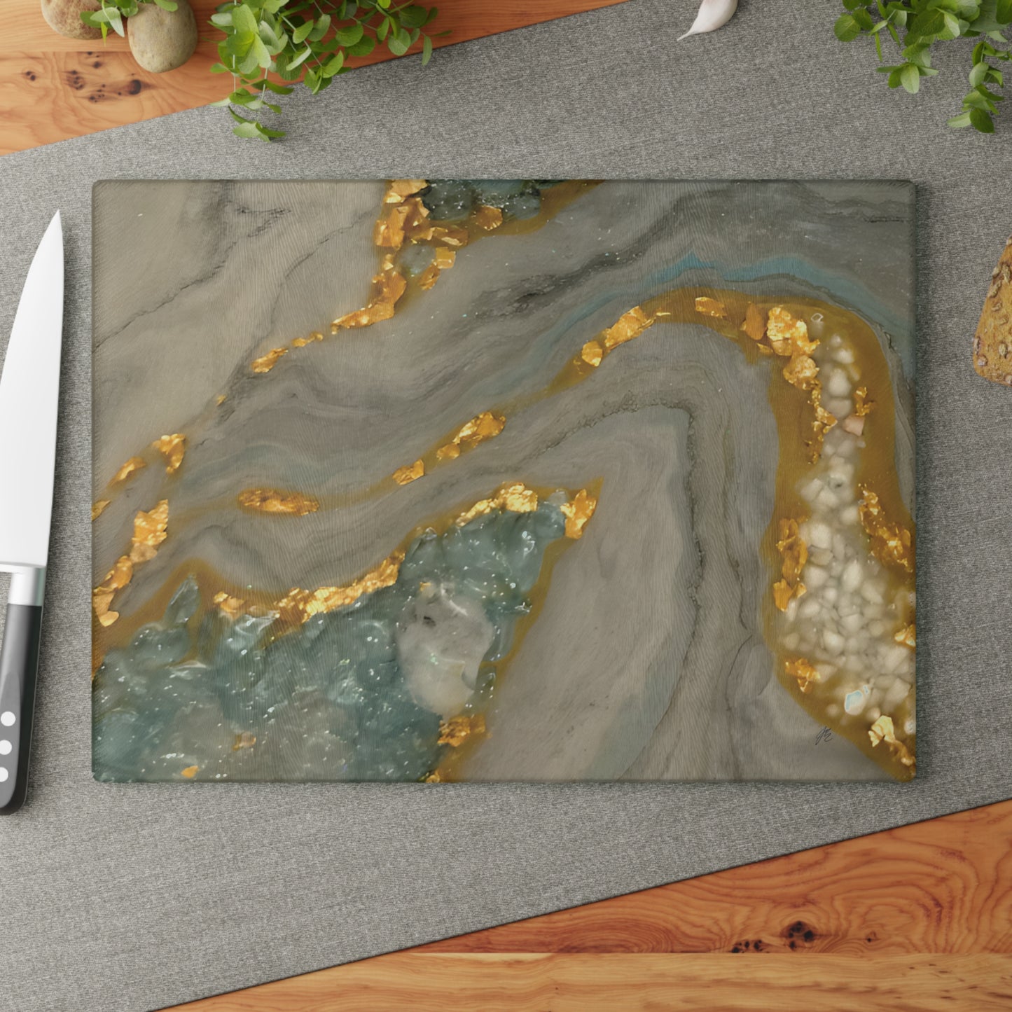 Marble-patterned cutting board with gold and gray design on a gray surface. Style by Jess