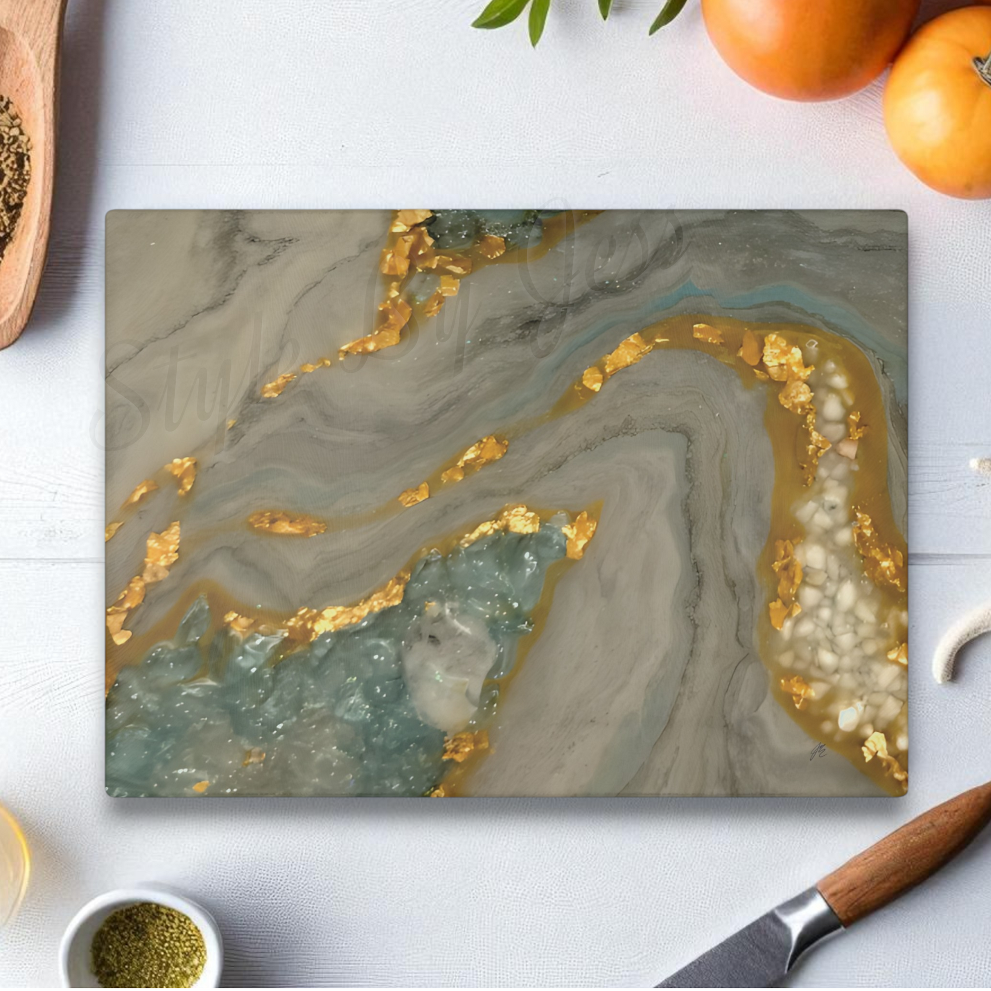 Marble-patterned cutting board with gold and gray design on a white surface with kitchen items. Gotta Have It Design a Style by Jess