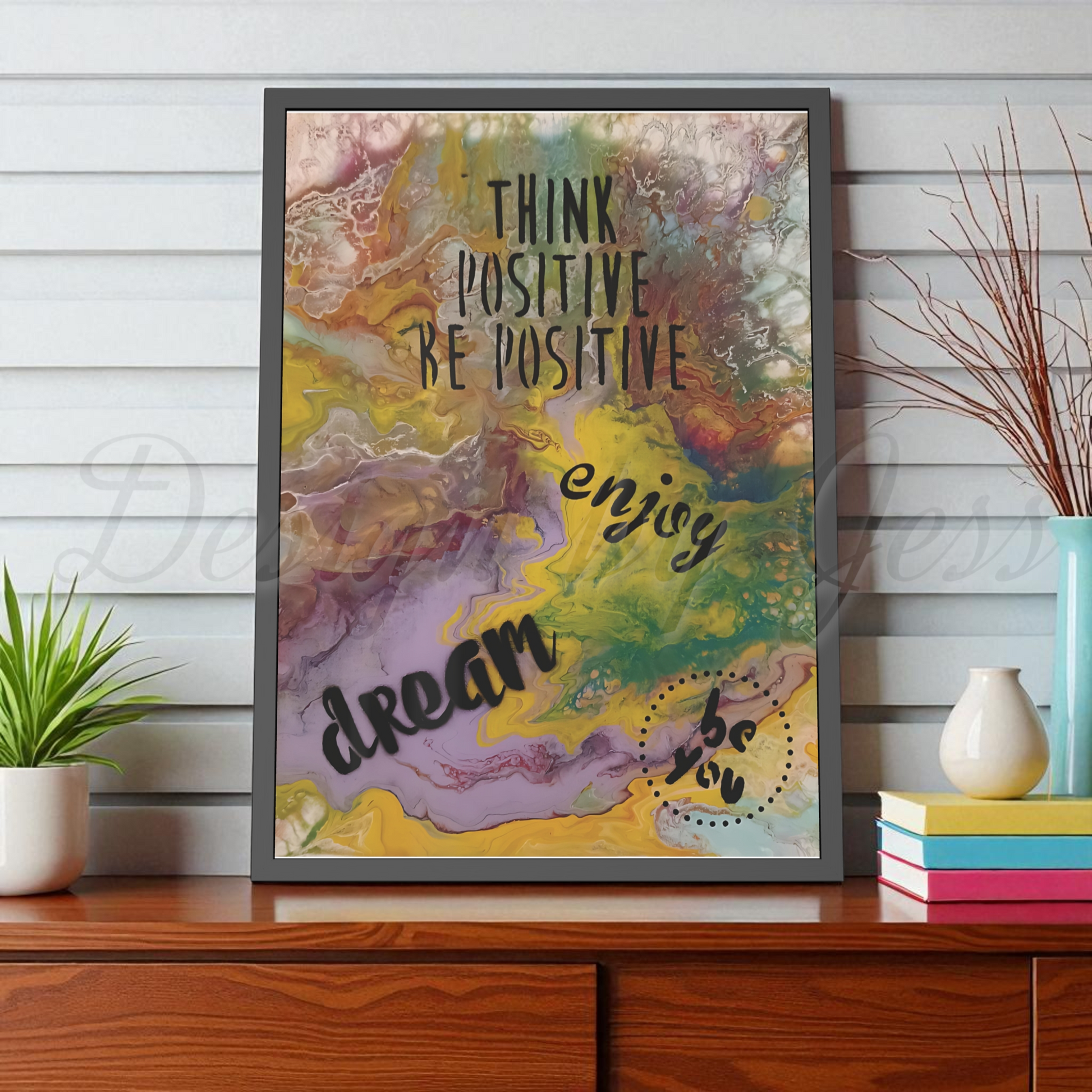 Framed colorful artwork with motivational text on a wooden surface.