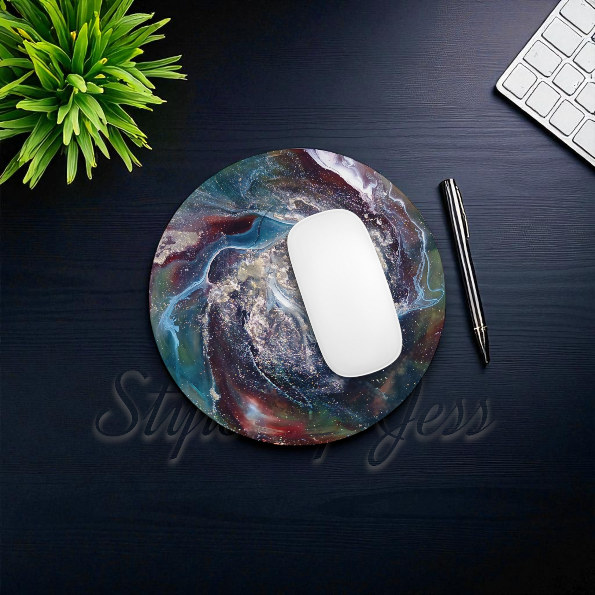 Colorful mouse pad with a mouse, pen, and keyboard on a dark surface.