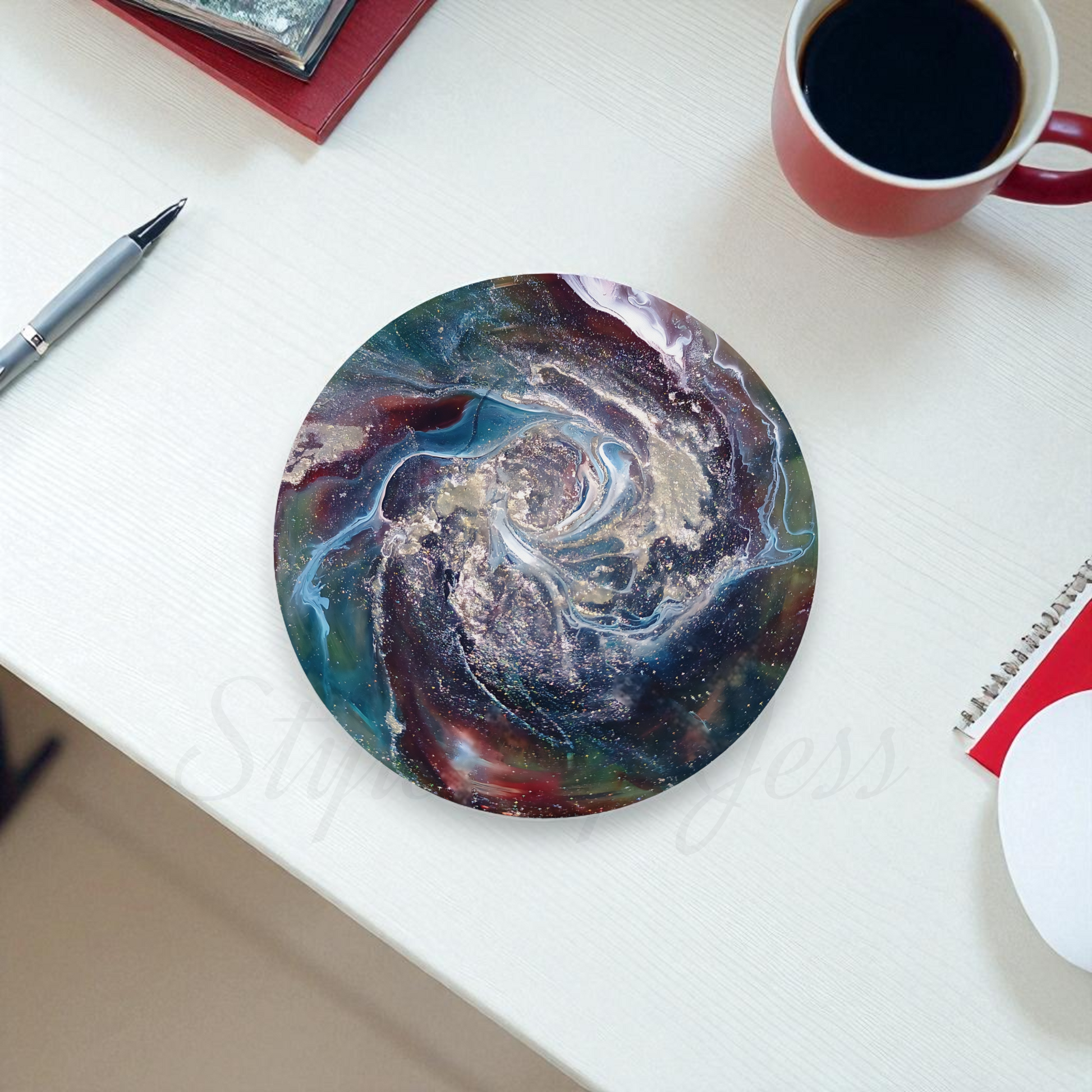 Round marbled mouse pad on a white surface with a cup of coffee and pen.