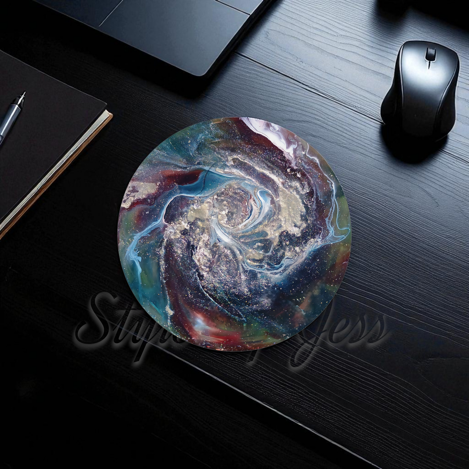 Colorful round mouse pad on a dark wooden desk with a laptop and mouse.