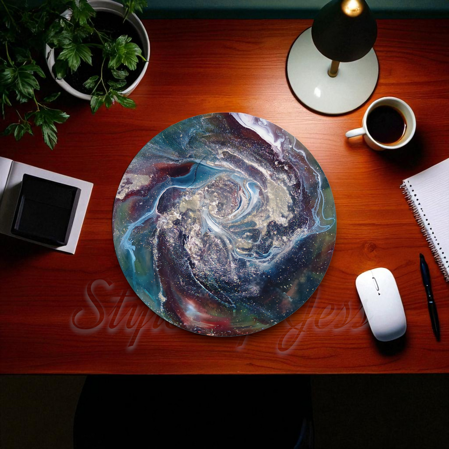 Round colorful mouse pad on a wooden desk with a cup of coffee, lamp, and office supplies.