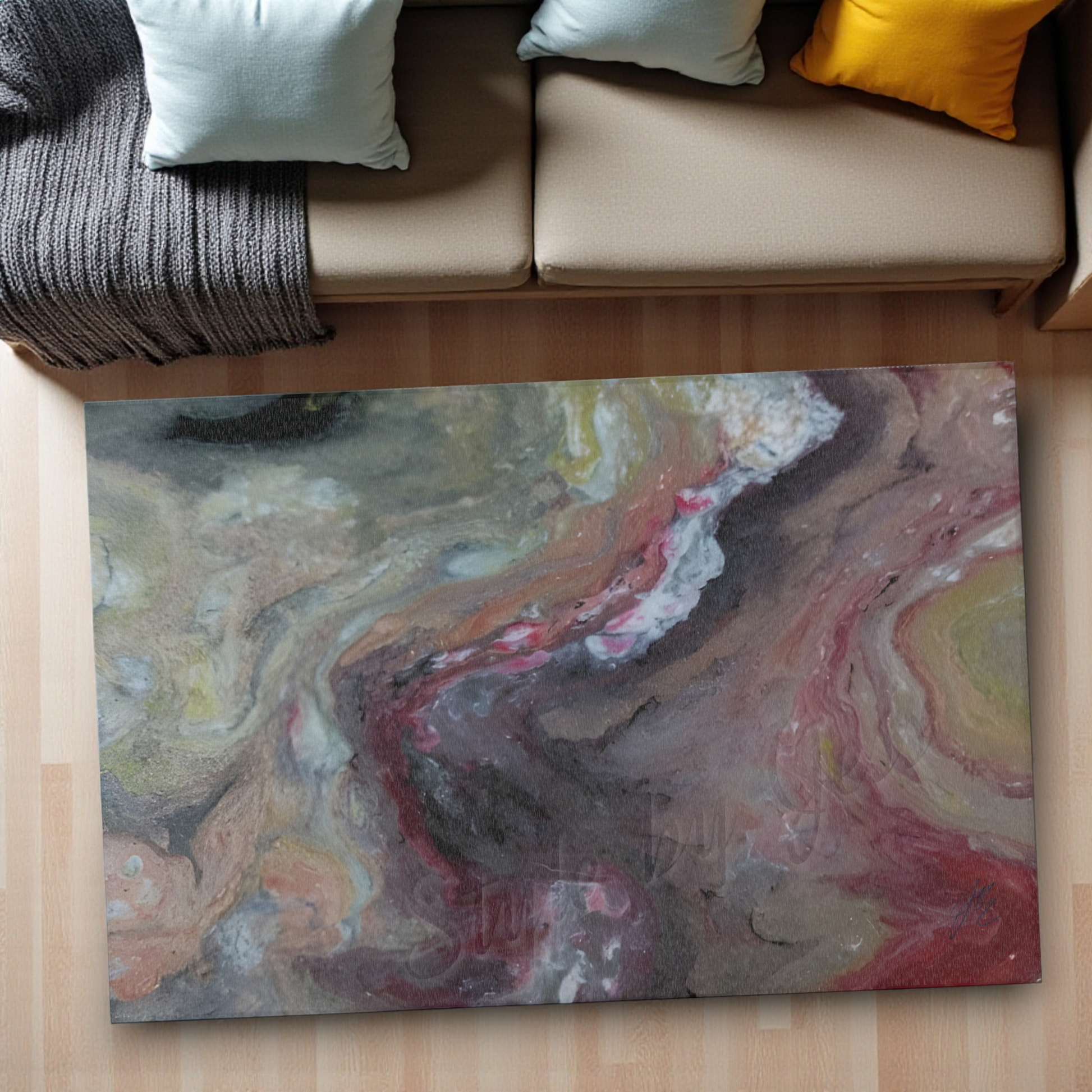 Abstract patterned rug on a wooden floor with a sofa in the background