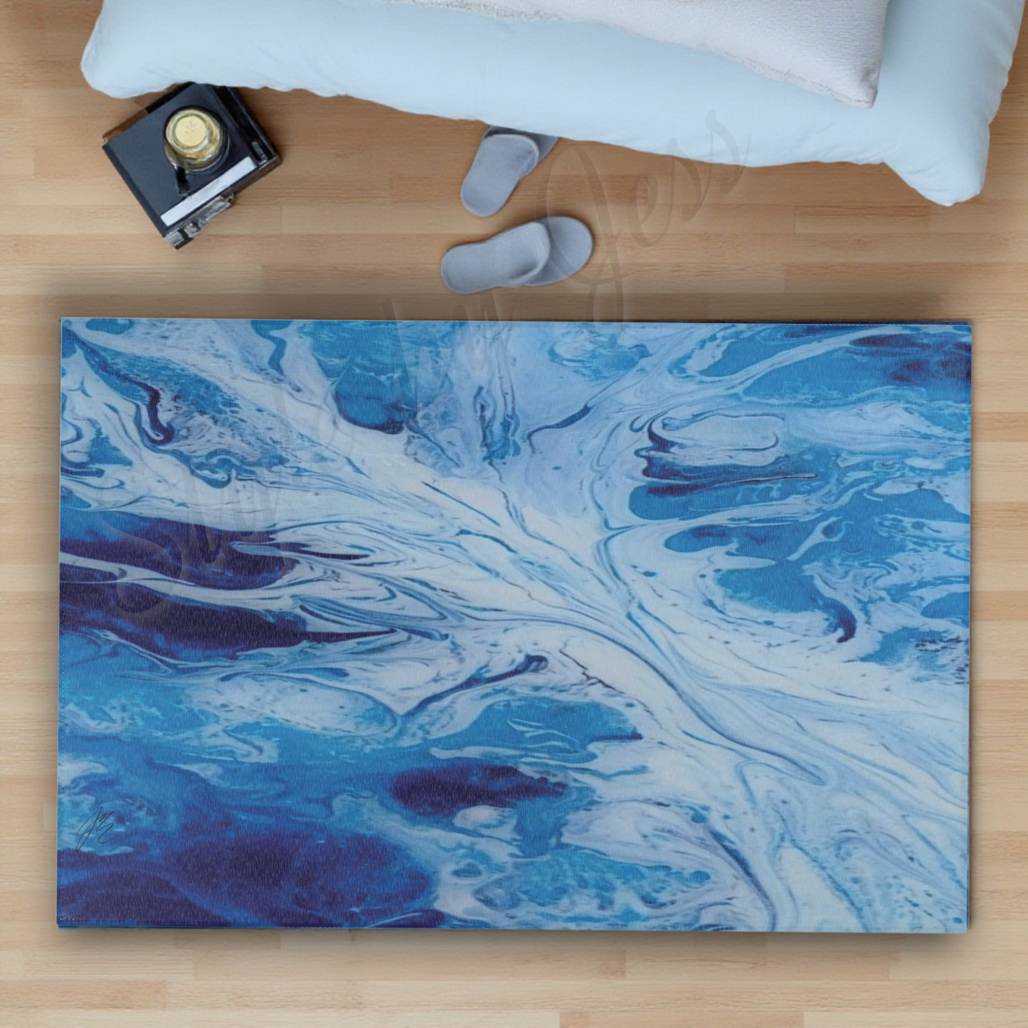Blue abstract accent rug on a wooden surface with a camera and white pillow in the background.