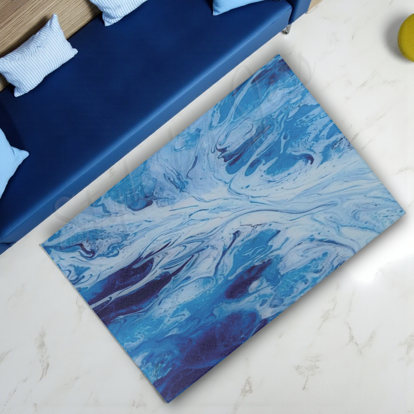 Blue marbled rug on a white floor next to a blue sofa.