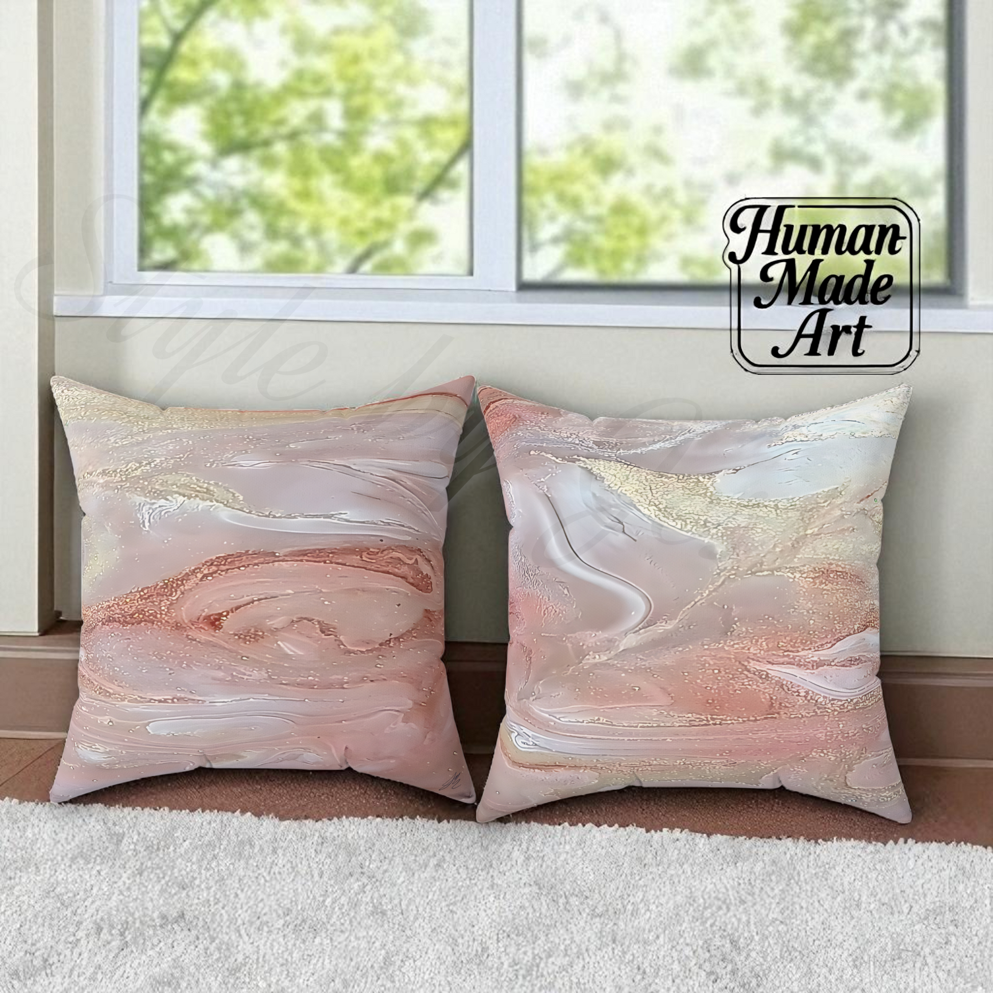 Two marbled patterned decorative pillows on a surface with a window in the background, branded 'Human Made Art'.