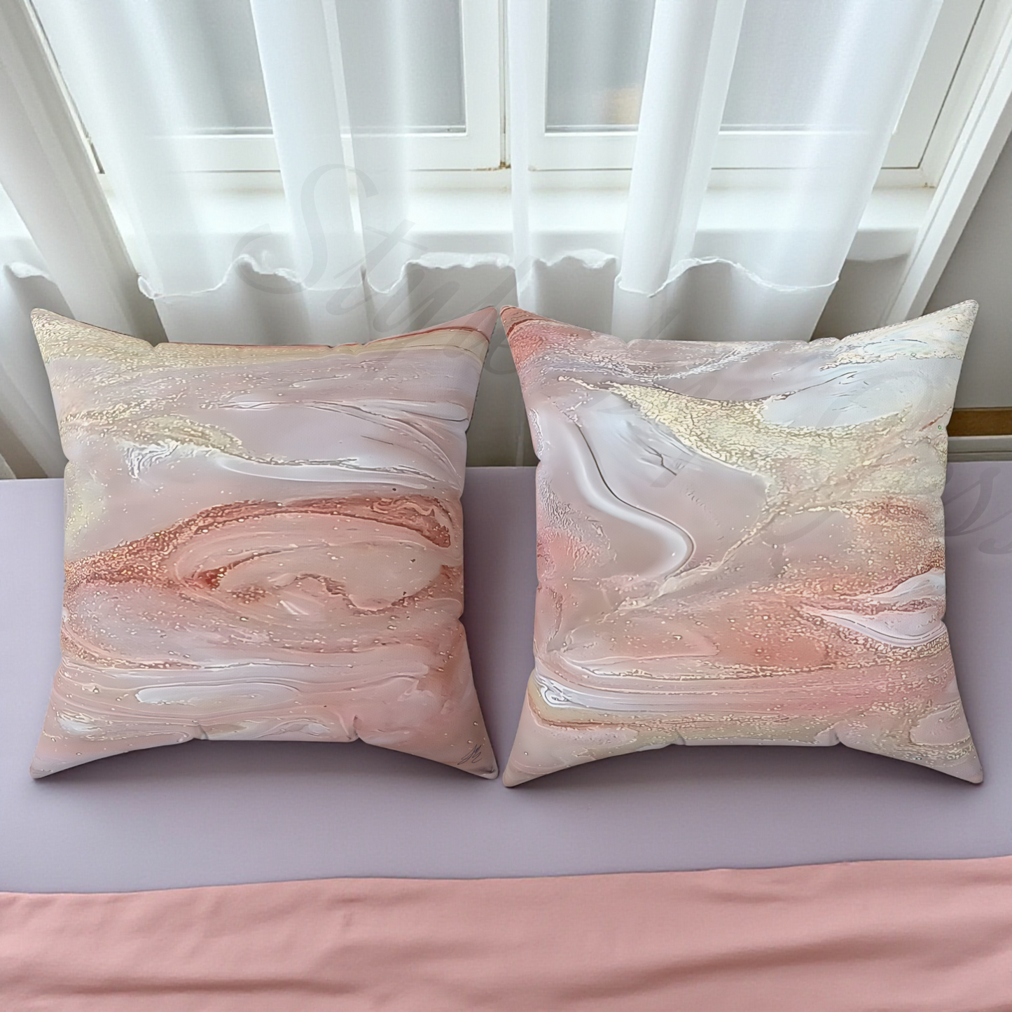 Two marble-patterned pillows on a bed with white curtains in the background