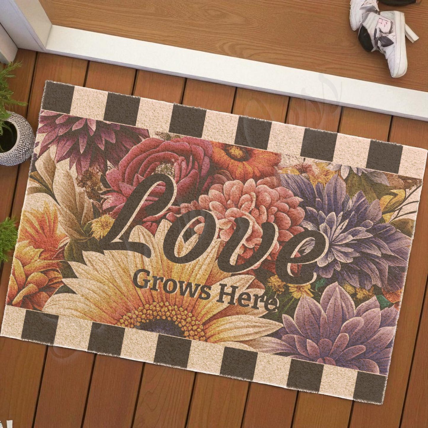 Decorative doormat with floral design and 'Love Grows Here' text on a wooden floor.