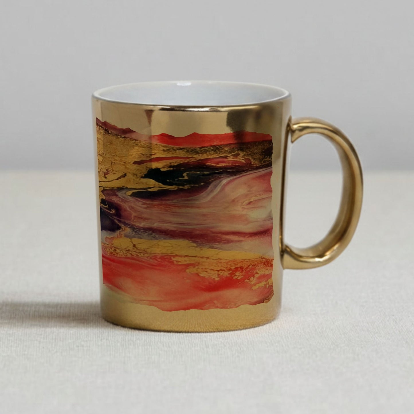Mug with artistic gold and red design on a neutral background