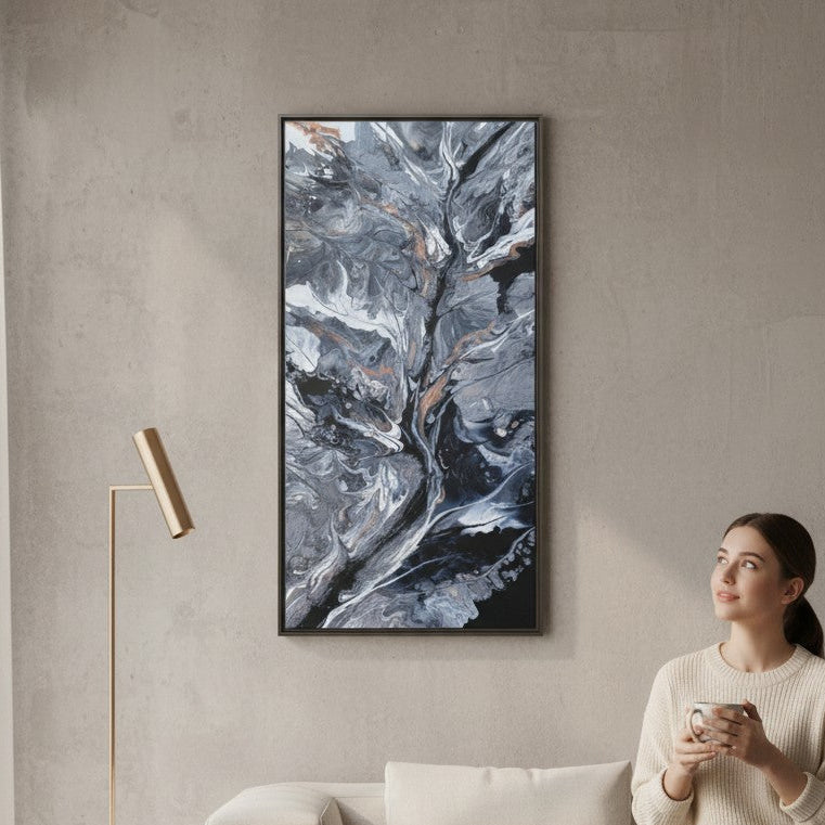 Woman sitting on a couch in a living room looking at the large abstract painting on the wall. A Style By Jess at Gotta Have It Design