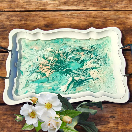 Decorative tray with marbled design on a wooden surface with flowers.
