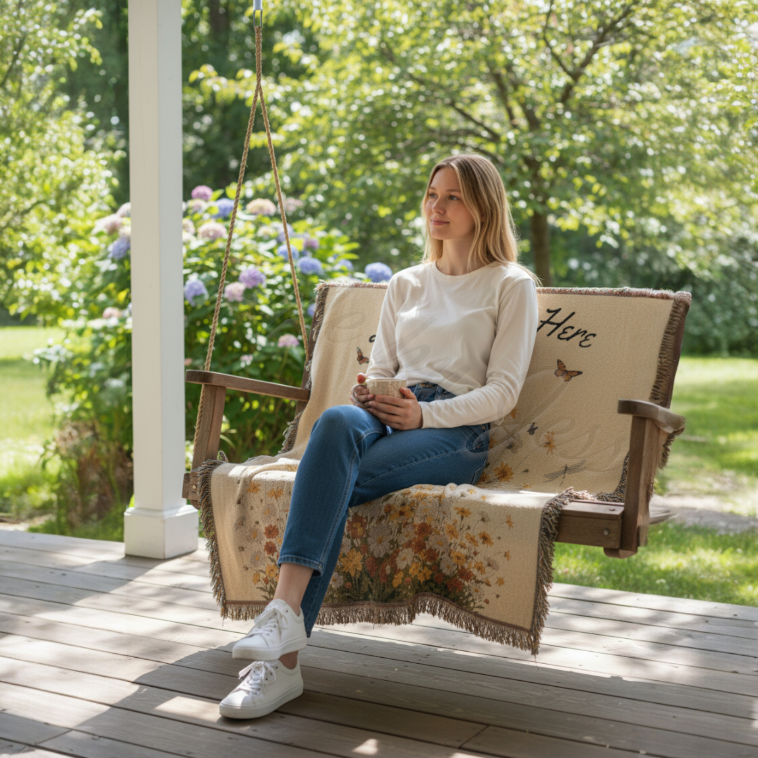 Woman sitting on a wooden swing with floral blanket on a sunny day.