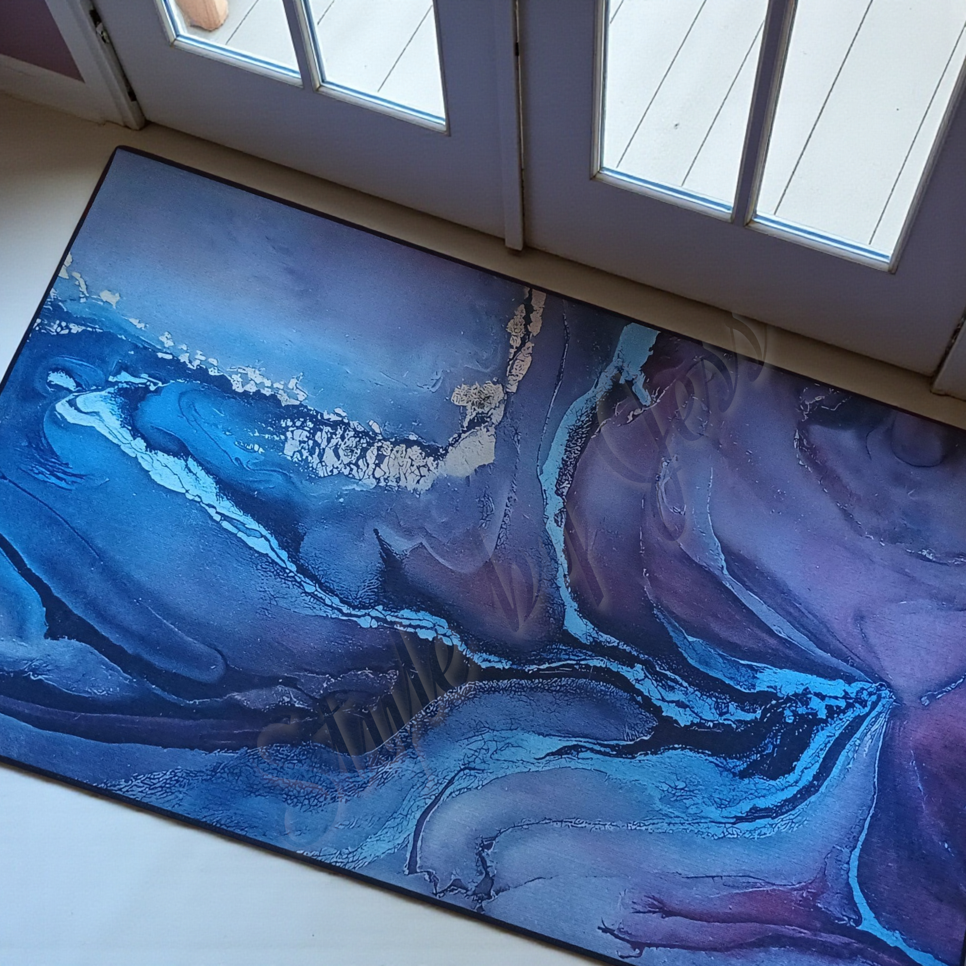 Abstract blue and purple rug on a floor with a door in the background
