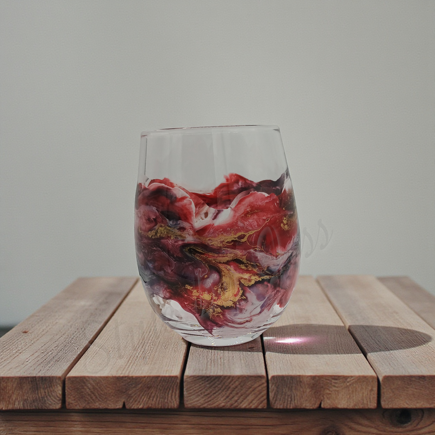 Clear glass with handmade abstract art marbled design on a wooden surface