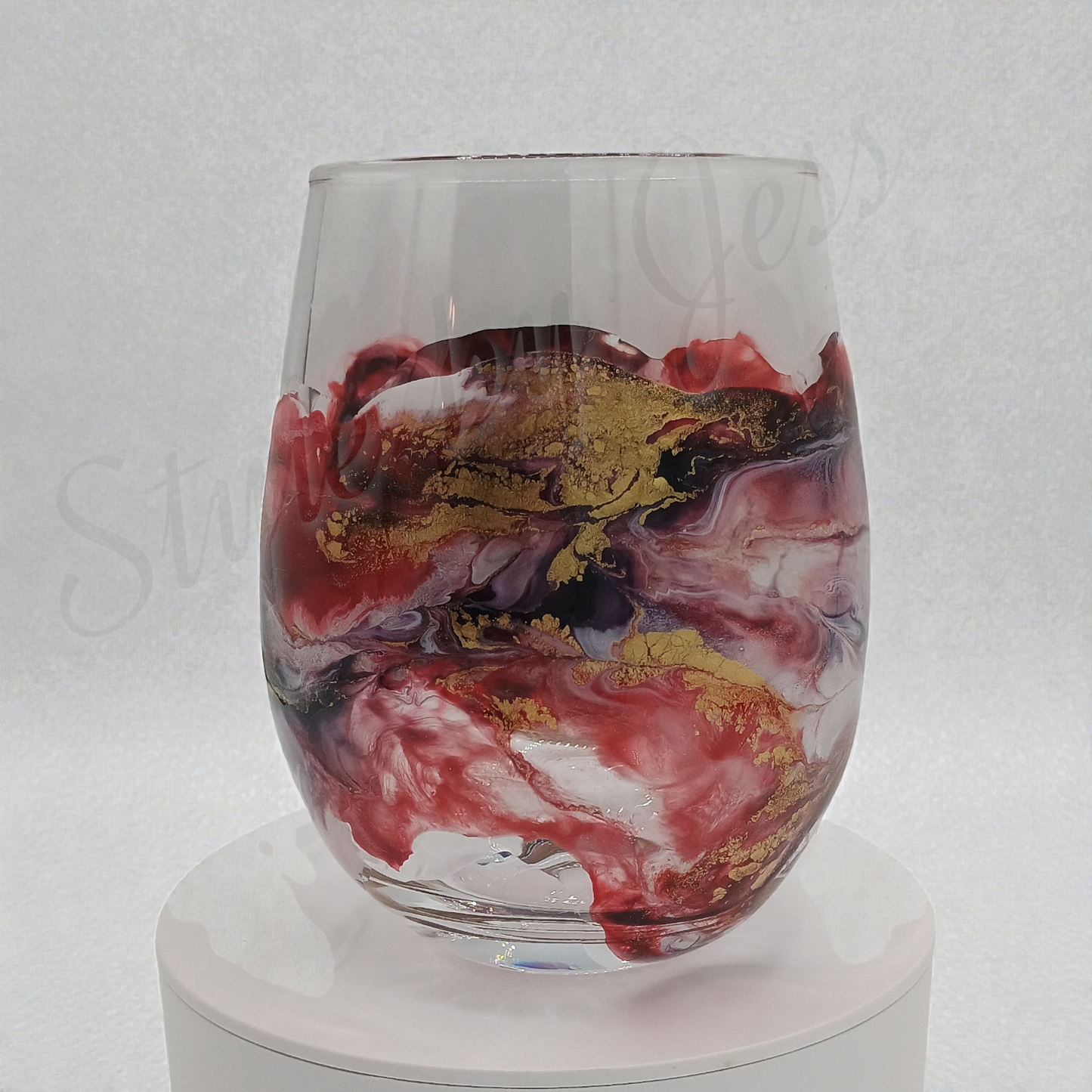 Glass with red, gold, and black marbled design on a white background Style by Jess at Gotta Have It Design