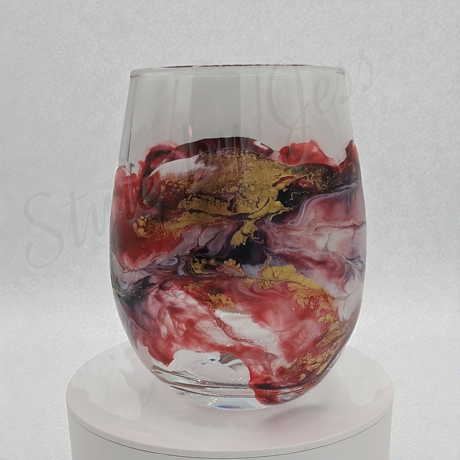 Glass with red, gold, and black marbled design on a white background Style by Jess at Gotta Have It Design