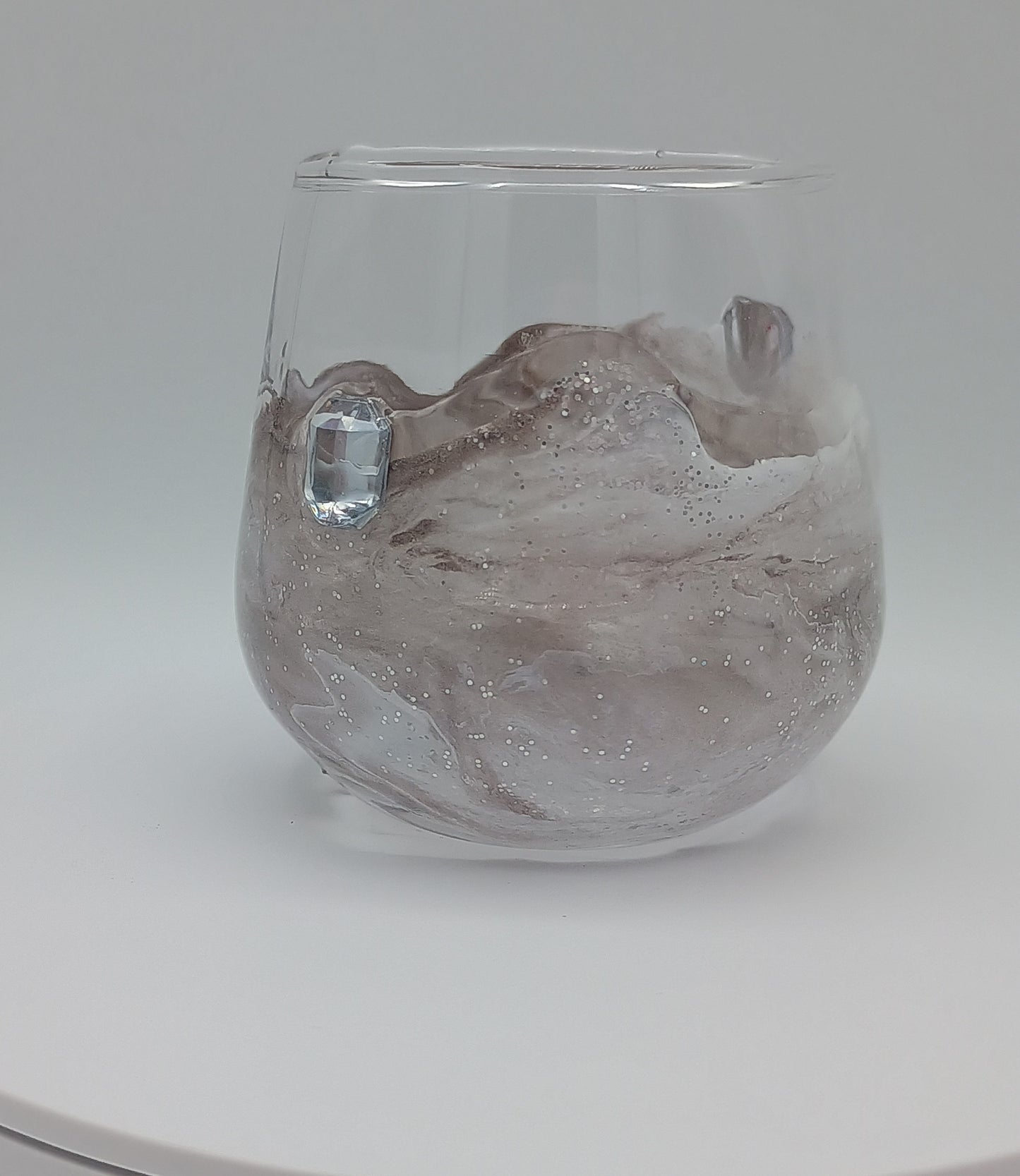 Shot glass with artistic custom marbled resin design on a white background perfect for birthday gift.