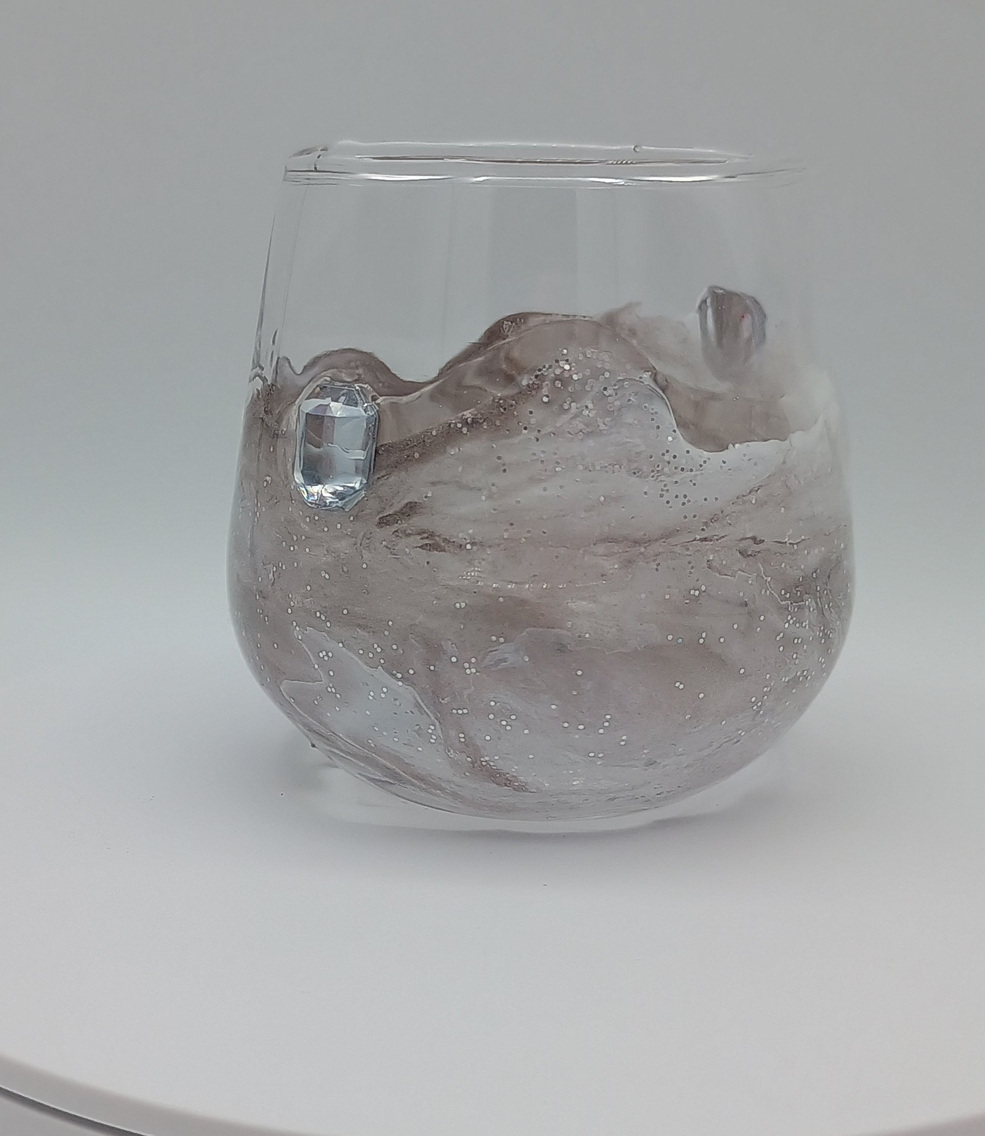 Shot glass with artistic custom marbled resin design on a white background perfect for birthday gift.