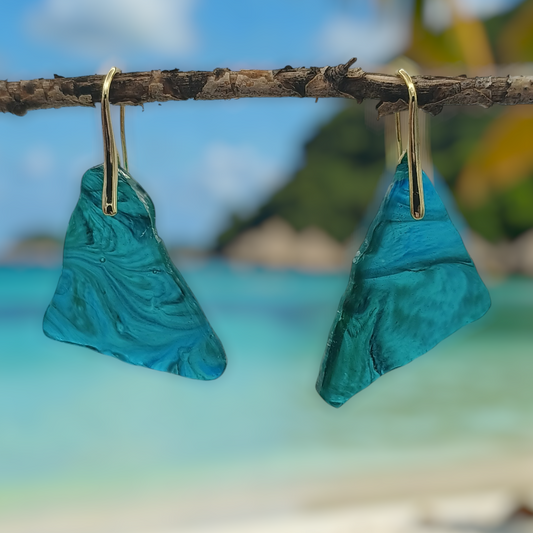 Blue triangle dangle earrings hanging from a branch with a beach and palm tree in the background a Style By Jess at Gotta Have It Design