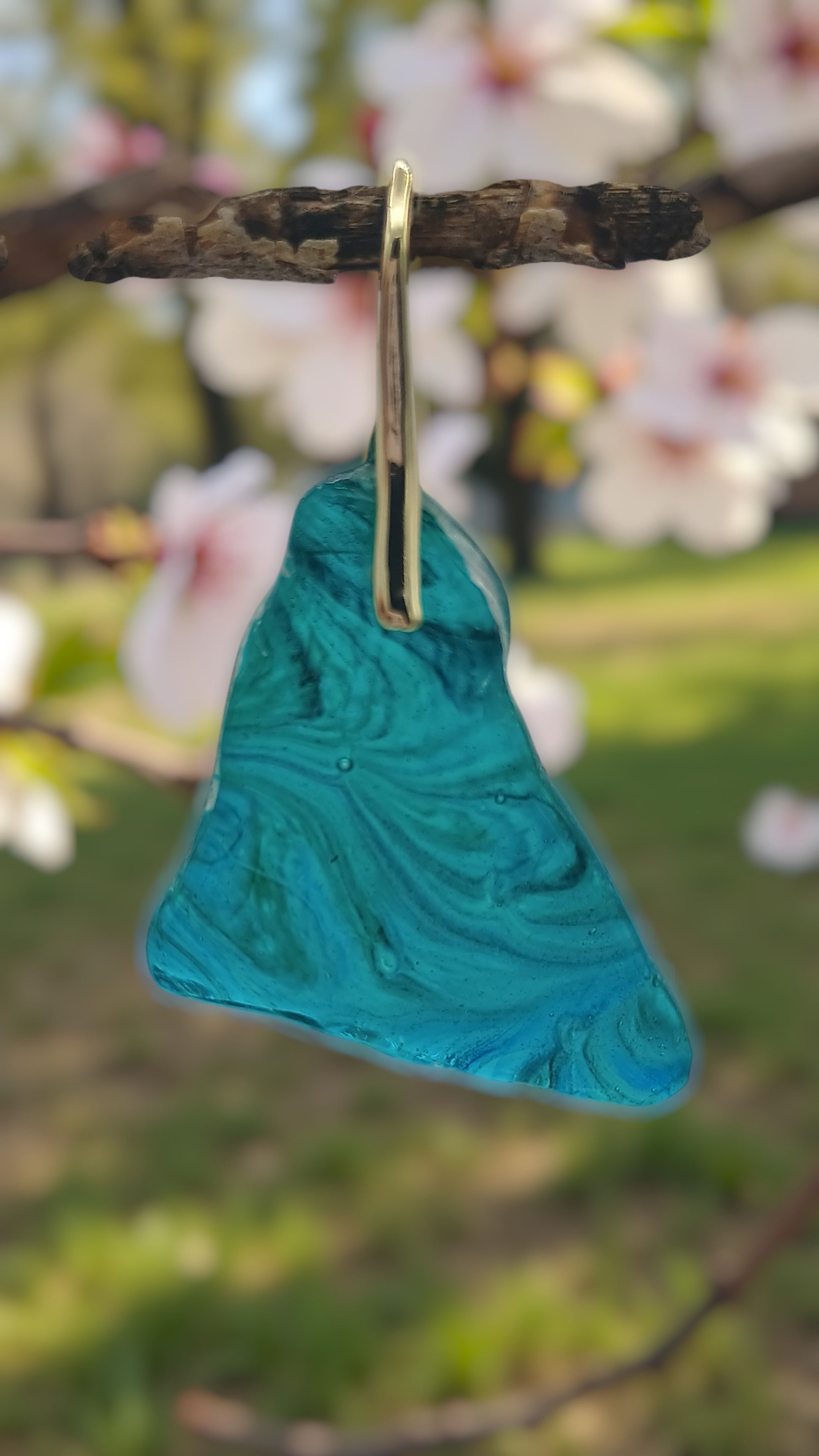 Turquoise earring with gold on a branch with blurred floral background great beach wedding present a Style By Jess at Gotta Have It Design 