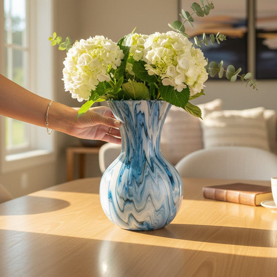 Blue marbled vase with white flowers on a wooden table as a centerpiece in a living room a Style By Jess at Gotta Have It Design. 