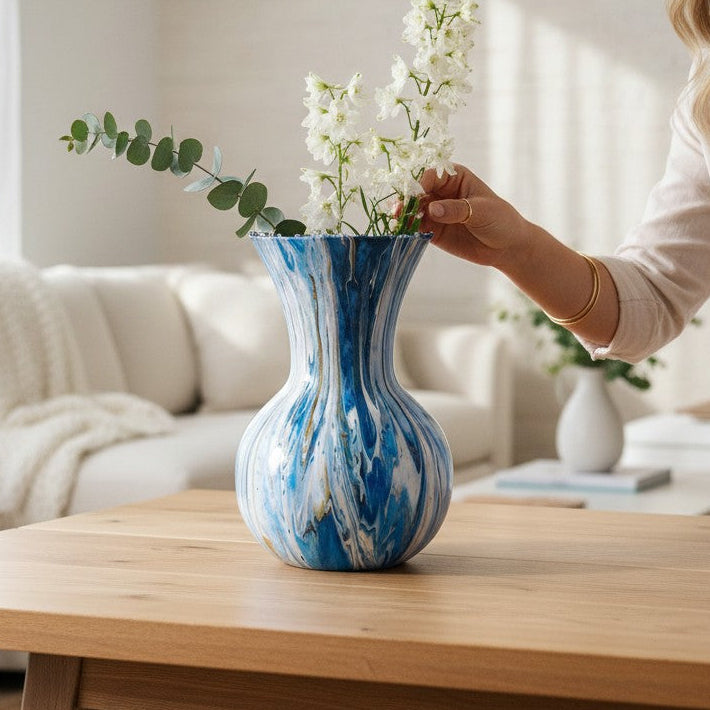 Woman arranging flowers in a blue and white vase on a wooden coffee table in a living room with a farmhouse decor a Style By Jess at Gotta Have It Design.