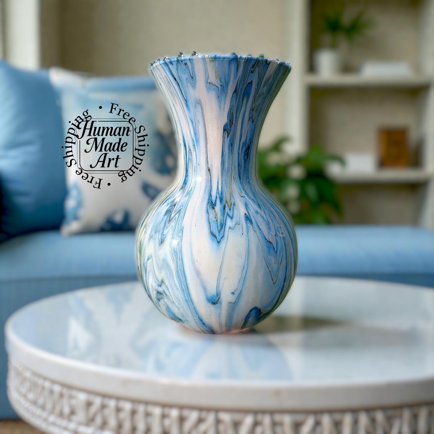 Marbled blue and white glass vase on a table featured as the focal point as a centerpiece with a blurred living room background