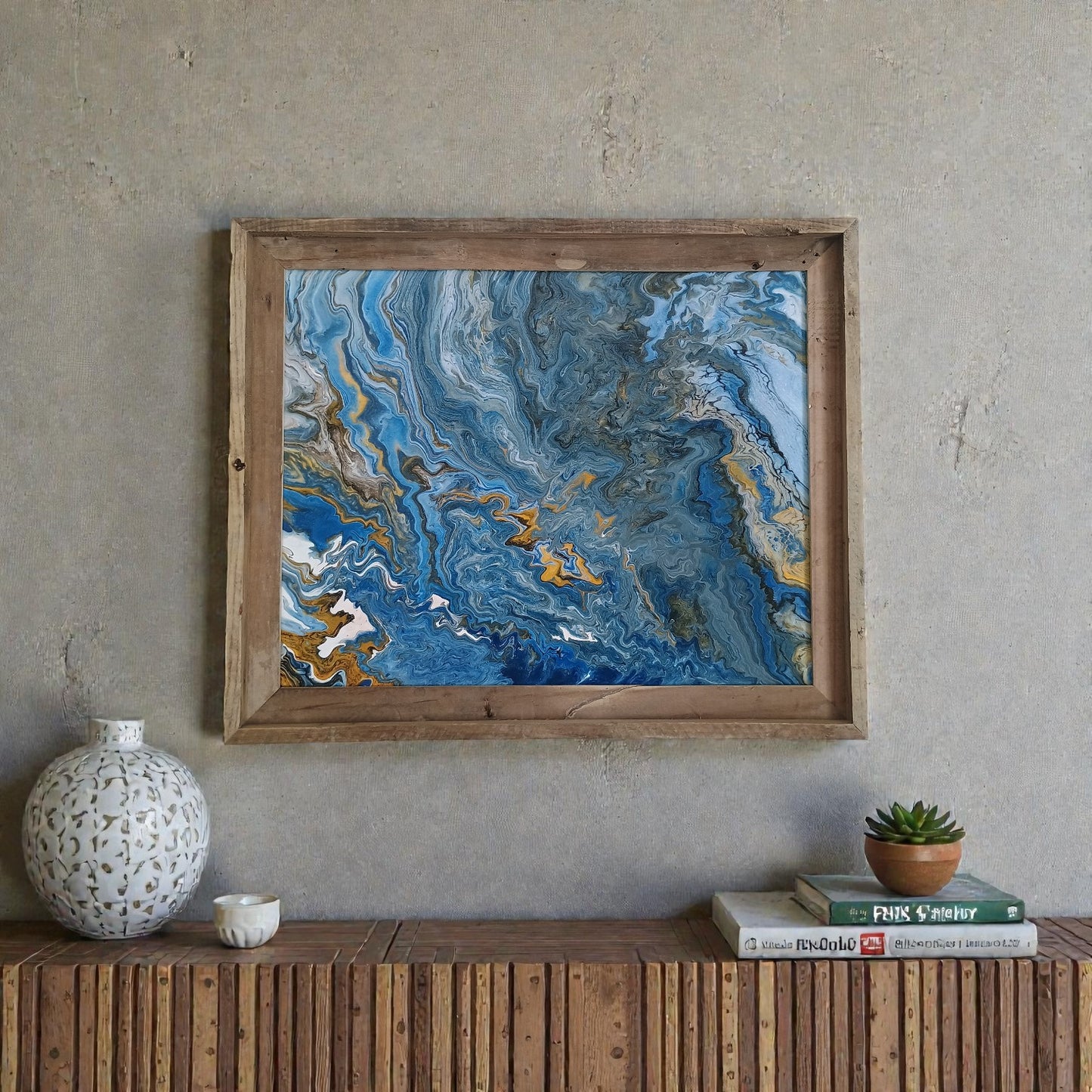 Framed abstract art piece on a wall above a wooden console table with decor items.