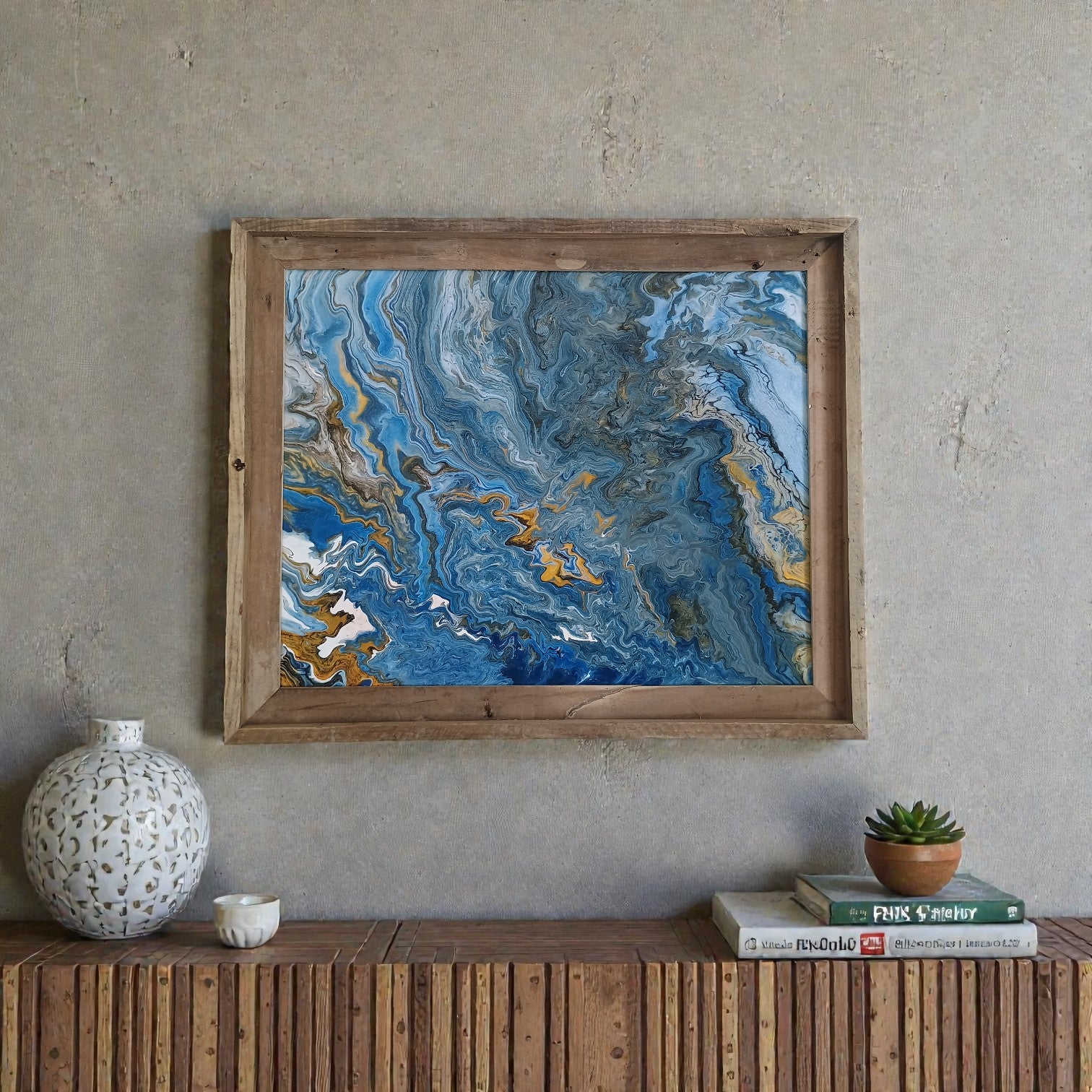 Framed abstract art piece on a wall above a wooden console table with decor items.