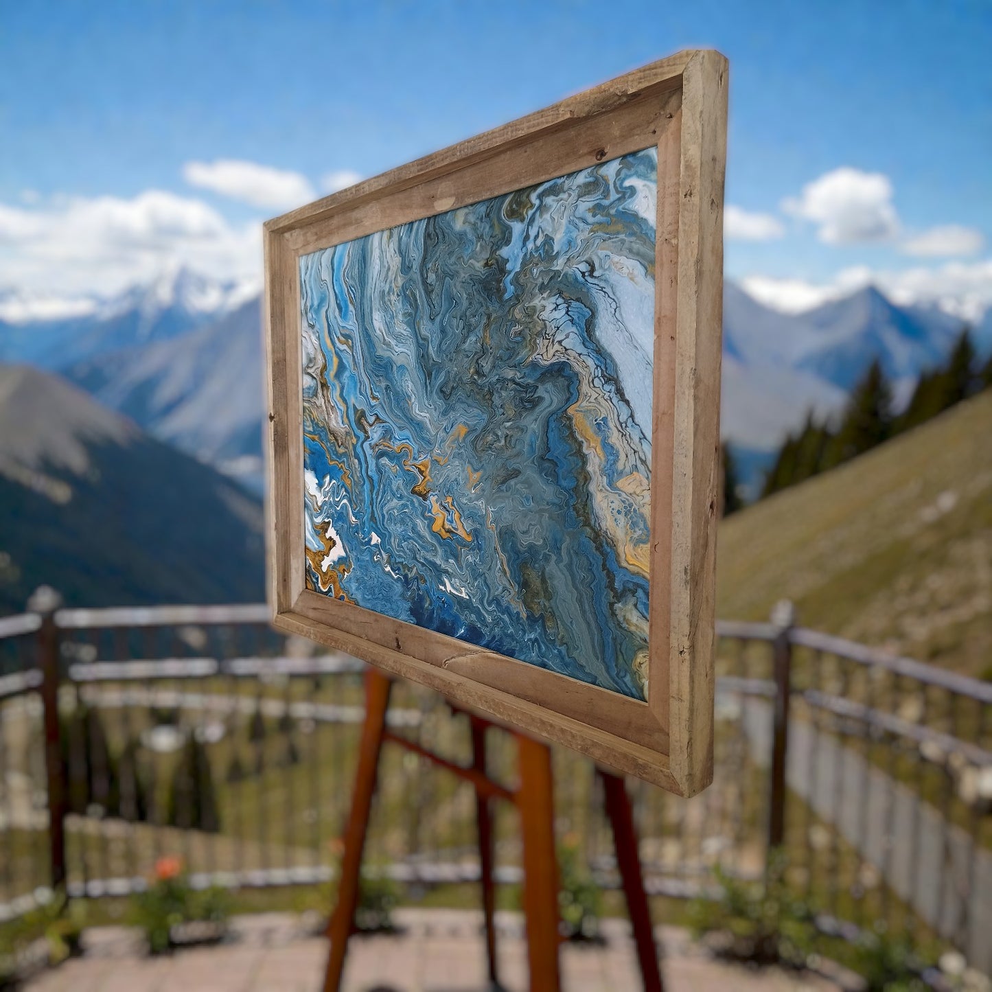 Custom original abstract painting in a wooden frame on an easel with mountains in the background. An original painting made in Colorado by Jess a Style By Jess at Gotta Have It Design.