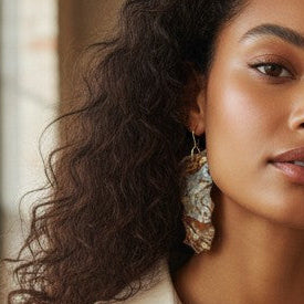 Woman showing off her custom earrings. 
